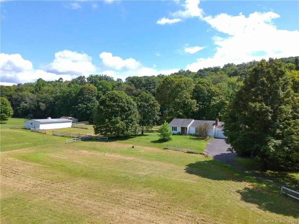 Whoa, Hold Your Horses! This two bedroom ranch house in the Minortown section of Woodbury is situated on over 4 1/2 acres and includes a four stall barn with plenty of pasture. Built in 1979, the house features wood floors, a living room with wood-burning fireplace, a deck off the kitchen and an attached two car garage. Heating is provided by a Burnham boiler installed in 2004. The well pump was replaced in 2021 and a new water softener system was installed in 2022. Enjoy peace of mind thanks to a Generac whole house generator with automatic transfer switch, new in 2021. The barn measures 48 x 30 with a 12' center height, sliding doors at either end and electricity (water may be there, but haven't confirmed that). This is a nice opportunity for someone who appreciates the charming character of Woodbury and the convenience of having their pets close by. Bring your ideas (and your horse) and make this property your own Dutton Ranch.