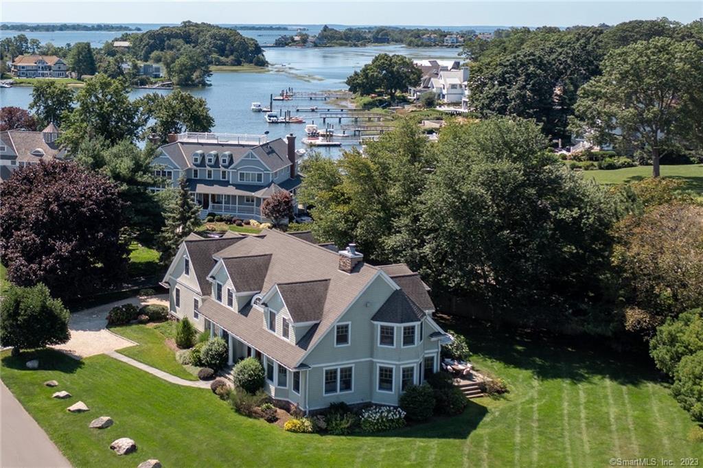 Take in the cool sea breezes and serenity of the water’s edge as boats come and go from Saugatuck Yacht Club's harbor. This spectacular custom-built Nantucket-style home enjoys the best of coastal living. Poised in the coveted waterfront community of Saugatuck Shores, walk to private neighborhood beaches, launch your kayak on the water or take a morning walk with friends along quiet neighborhood streets. Minutes from the restaurants and shops of downtown Saugatuck and the train. Pristine living spaces reflect quality craftsmanship and impeccable details. Move in on time to relax this fall by the gas fireplace in the living room with views of the harbor or by the wood-burning fireplace in the family room. The chef’s kitchen is home to an oversized island, wet bar and professional appliances. French doors in the family room open to the raised stone terrace, inviting you to pause and enjoy living and dining al fresco with views of the water. Work from home from the tidy first-level office. Upstairs, the primary suite features a gas fireplace, spa bath, and water views. A gracious guest suite and two oversized bedrooms sharing a large Jack and Jill bath offer easy accommodations for family members. The landing features an open bonus room, the perfect space for a game room or media room. An additional room could serve as a gym, home office, or potential fifth bedroom. Whole home generator and room for a pool off the stone terrace to complete your slice of paradise.