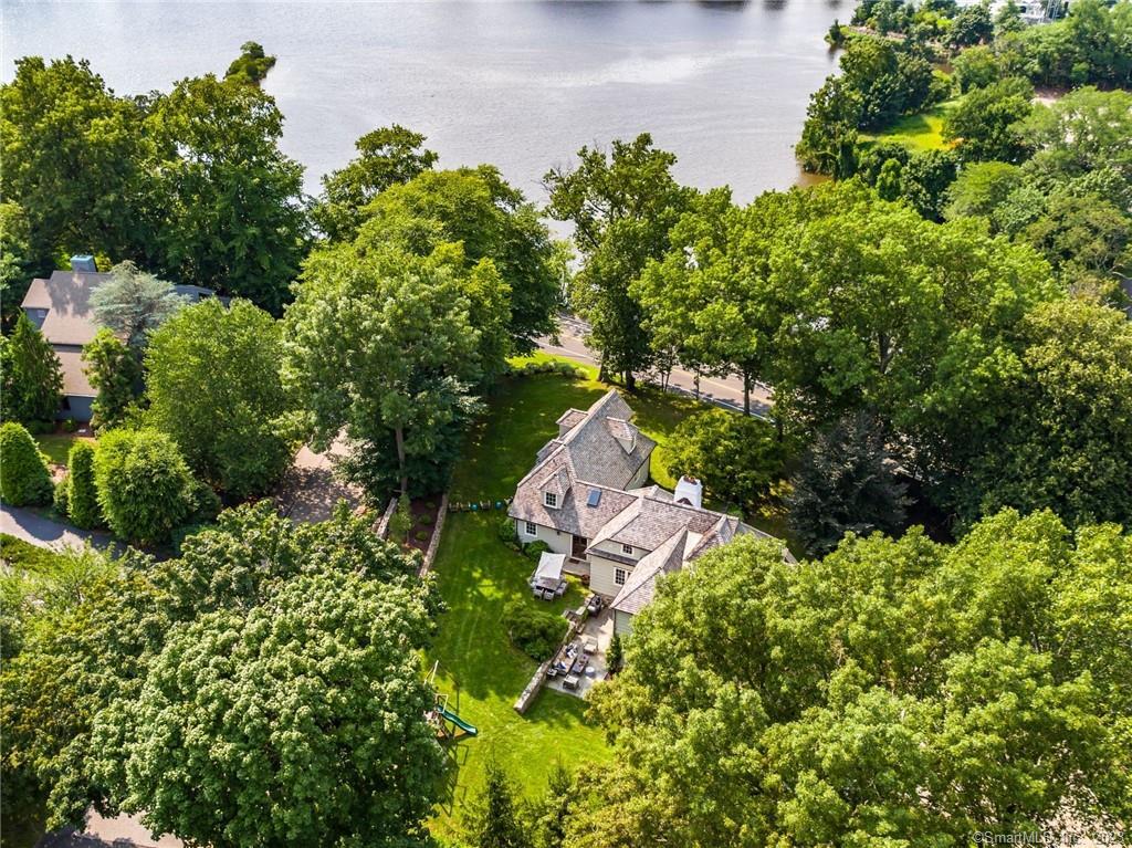 This enchanting restored Tudor is a crown jewel. Enjoy water views, steps from downtown Westport. Set up and back from the scenic Saugatuck River, this c. 1934 masonry home is replete w/every amenity for luxurious & comfortable living. Extensively remodeled, a complete re-envisioning of this gem resulted in a modern, chic home blending today’s style & convenience w/the unmistakable character & authenticity of the original masterpiece. One of this home’s signature features is the open gourmet kitchen with built-in “pizza oven” and all the upscale amenities, centered around a massive island with seating. An adjacent oversized walk-in pantry allows tremendous storage & organization outside of the main space. This phenomenal entertaining space flows to the family room w/French doors to the patio. An incredible Great Room w/river views, barrel ceiling & custom fpl has a bar/office beside it. The master suite is privately set w/commanding water views; the lavish BR w/fpl, ample closets and lux bath will delight. Each BR offers unique character, the 5th is tucked away as a private suite - the layout offers flexibility for your needs. Multiple private home offices. The walk-out LL has a spacious gym/bonus area. Conveniences incl 2 laundry rms, mudroom entry, town water, sewer & gas. The picturesque grounds have postcard views of the river & room for a pool. Stroll to the Farmer’s Market, library, summer concerts at the Levitt and popular dining/shopping