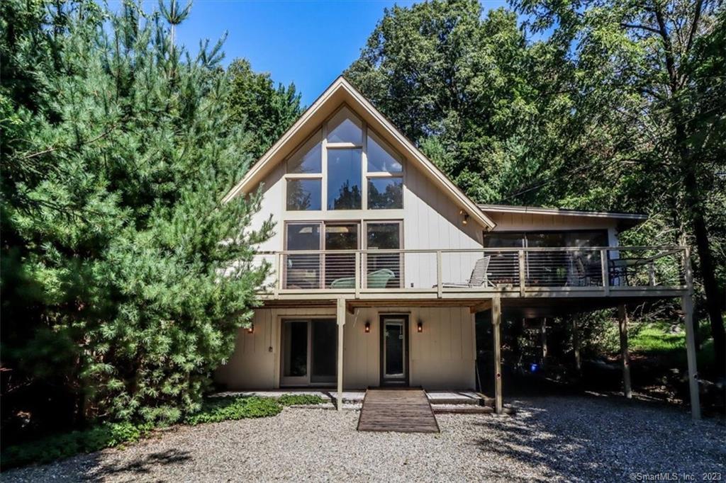 Custom-built Contemporary home with walls of glass and full of light. Peaceful, remarkable, and set back on long driveway in secluded park-like natural setting. Lots of room for parking. Private and comfortable with desirable location in Westport, CT, minutes from train, beaches, recreation and shopping. Stunning living room on main level with majestic natural views, soaring beamed cathedral ceiling and floor-to-ceiling brick fireplace for cold winter nights. Walls of glass overlook the mature garden setting from dining room. Large 3-season room with fabulous wrap around deck. Galley kitchen. Breakfast bar. Hardwood and tile floors. Open all the sliding glass doors and enjoy the breezes in a wonderful balance of indoor to outdoor living. Open-staircase leads to third-level primary bedroom suite with balcony overlooking main level, double closet space and private deck. Lower level includes cozy, great room with fireplace, full bath, two private rooms that can be used as home office space with ample closets. Discover the secret garden stone patio, nestled off the back. Separate front entrance from marble-tile patio. This tranquil home is not only beautiful but filled with so much flexible space to suit many needs!