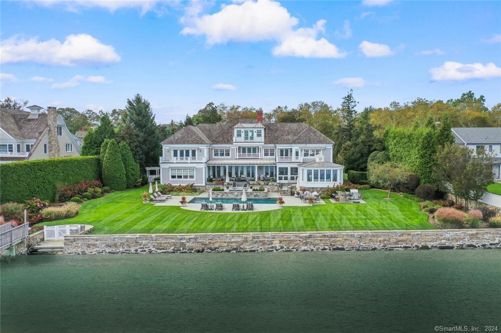 Spectacular direct waterfront estate offering unobstructed views of Long Island Sound. Marvel at sunrises over the water and watch wildlife, boating and aquatic activities from your private piece of paradise. Launch your boat and wave runners from the 20 ft. floating dock and join the fun. Enjoy complete privacy from the meticulously landscaped 1.3 acres with a 168-foot seawall, 80-foot pier, and private beach. A heated pool /spa with expansive granite patios and multiple covered seating and dining areas provide the ultimate setting for waterside entertaining and relaxation. Front row seat to Westport's fireworks. No expense was spared in creating this 14 room custom manor house. Incredible attention to detail is evident throughout with its fine moldings, heated floors, onyx trimmed Art deco bar and glassed walled conservatory with forever views. The charming 2 bedroom cottage offers endless possibilities for guests or work from home office. This waterfront escape is just minutes to all the amenities that make Westport celebrated including Compo Beach, Longshore Club Park, Westport Country Playhouse, Levitt Pavilion, and Downtown Main Street Shopping and Restaurants. Please view the tour and video.