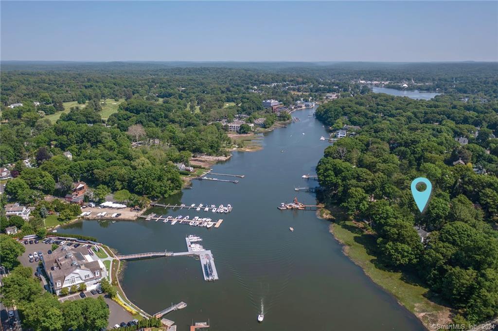 Enjoying spectacular panoramic views of the Saugatuck River, come home to an architectural gem poised on a quiet cul-de-sac at the water’s edge. Expansive windows highlight water views from almost every room where you can watch rowers and wildlife along the river. Entertain on the balcony overlooking the water and throughout chic living and dining spaces. Soaring ceilings, floor to ceiling windows and dramatic floating staircases create a light and bright retreat. The primary bedroom suite is home to a spa bath and private balcony perfect for enjoying a glass of wine in the evening looking out at the incredible sunsets. Fish, swim and paddle board from your own backyard or launch your kayak to explore the river or row to dinner at local restaurants. Walking distance to the train, the Saugatuck Rowing Club, and the restaurants and shops of downtown Saugatuck, this waterfront oasis has it all.