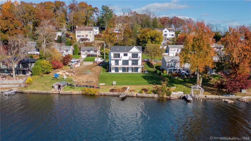 Rare Opportunity! Own the only newly constructed, ready for occupancy, Candlewood lakefront residence .This western facing waterfront home features  unparalleled distant views from a panoramic wall of lake-facing windows, expansive decks and one of the most level lots on the lake. Enjoy the Lower Level walkout, waterfront, Entertainment/Family Room with a second stunning full Kitchen, exercise room, full bath and laundry room. . The spacious Primary Bedroom boasts extensive & distant Lake views, cathedral ceiling, Walk-in Closet and a spacious & luxurious Bath. Revel in 88 feet of prime Lake Frontage for your leisure. Ideal deep water for boating and water sports. 16x20 ft dock included, sports equipment storage room and a large heated 2 car attached garage. Don't miss out on this extraordinary chance to call Candlewood Lake home!