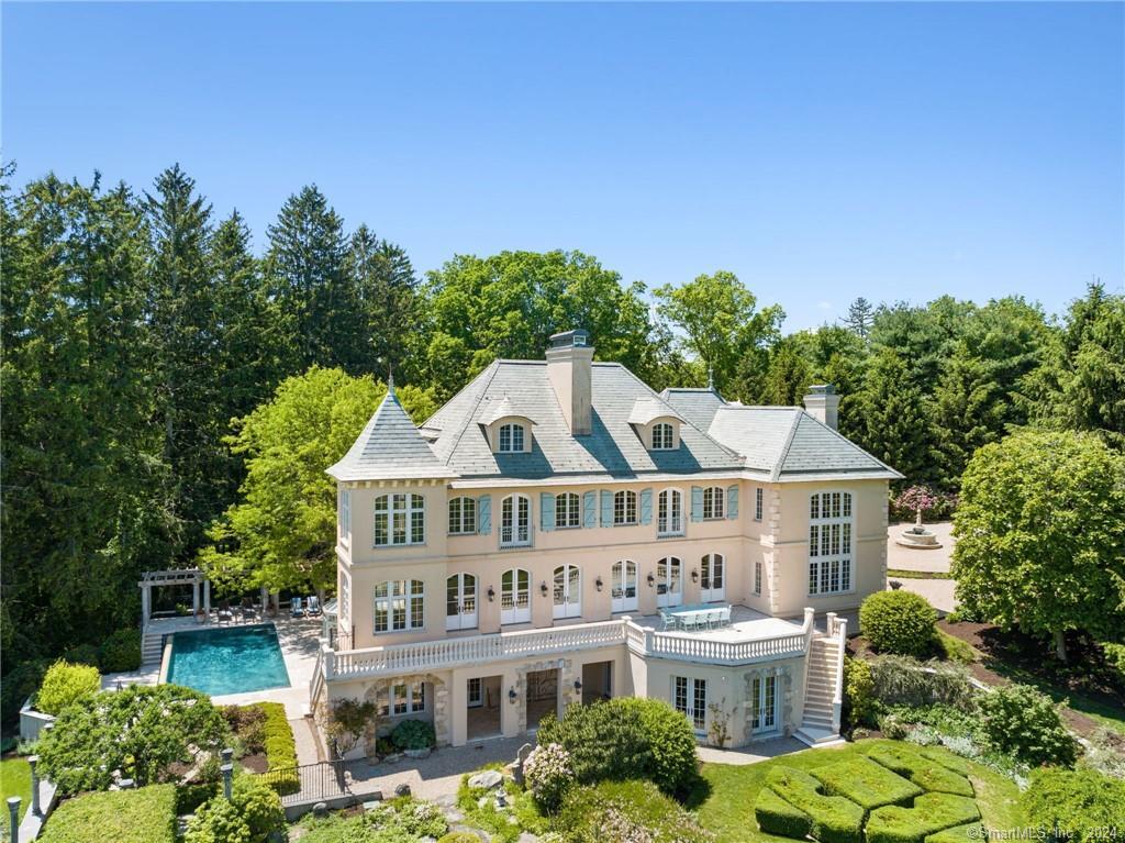 Be transported to Europe, without leaving the country! Experience breathtaking water views from this extraordinary estate nestled on 2.29 acres in South Wilton. Embracing European elegance, this coveted Nod Hill residence exudes luxury & meticulous craftsmanship from its slate roof down to its pool-side solarium. With soaring ceilings, limestone fireplaces, custom millwork & the finest materials imported from France & Italy, every detail reflects unparalleled quality that would be hard to duplicate today. Spanning 4 finished floors, this home offers space for all to enjoy–from quiet, cozy gatherings to grand parties. Entertain with ease! The light filled interior seamlessly blends modern comfort w/timeless elegance. The chef’s kitchen features top of the line appliances, pantry, fireplace, dining area & French doors opening to the terrace. The 2-story family room/library w/stunning fireplace offers a cozy space to enjoy quiet time w/a book or media. The primary suite provides a private oasis w/sitting room, luxe ensuite bath & fireplace. The piece de resistance is the stunning property…terraces overlooking Streets Pond, patios by the infinity edge pool, atrium, manicured gardens w/fruit trees & sweeping lawn. The pool “house” w/kitchenette, full bath & space to lounge, is perfect for hosting summer gatherings. With the allure of water views & gracious sophistication, this home offers a sublime lifestyle. Don’t miss the opportunity to own this exceptional piece of paradise.
