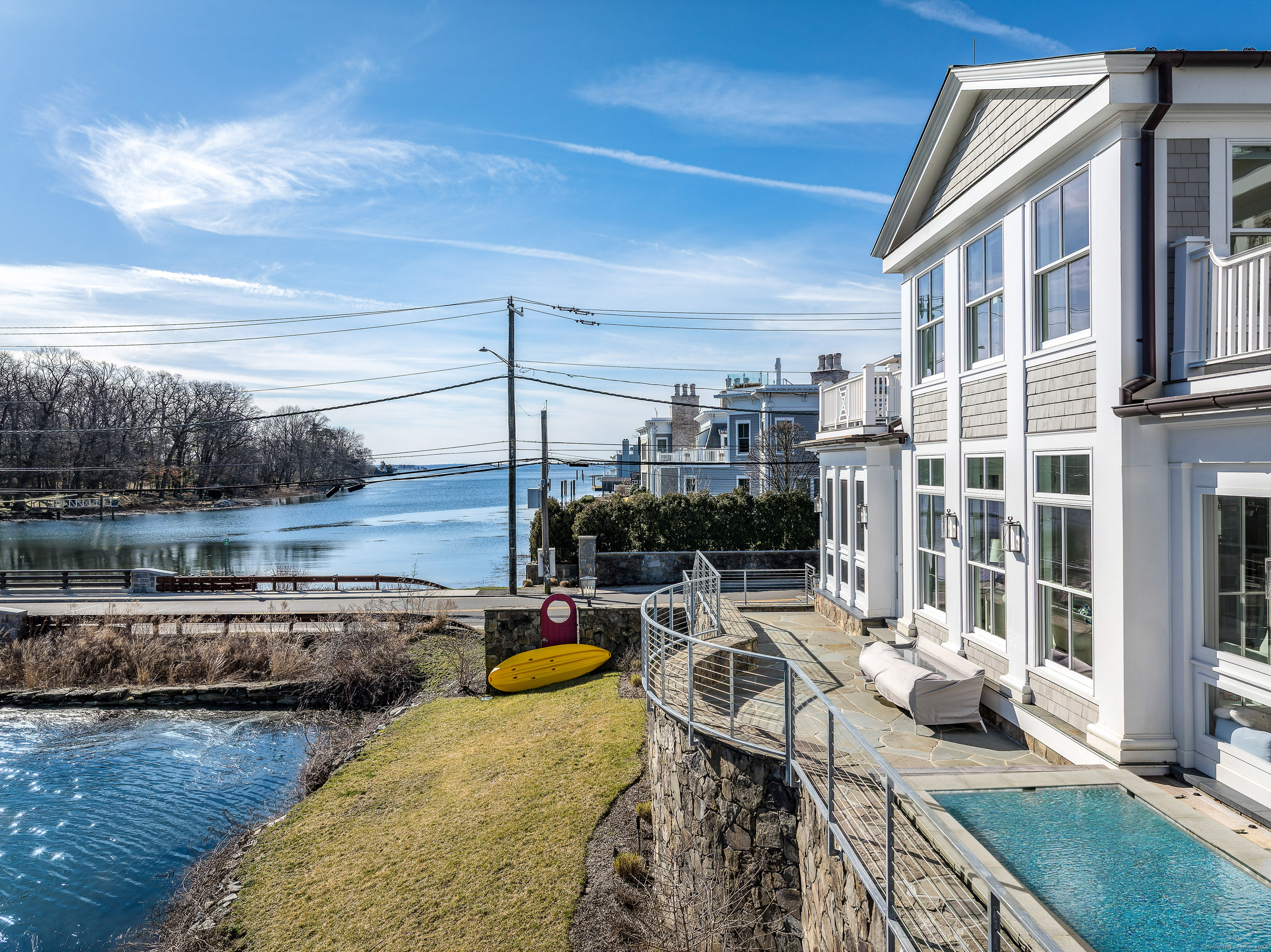 Breathtaking waterfront home, totally transformed into a stunning turnkey showcase. Set high above the water with amazing water views of the Long Island Sound and Smith Cove, it is walking distance to Greenwich Ave restaurants, train, park and ferry boats. Designed by VanderHorn Architects, great attention is given to providing sunlit rooms and well thought-out additions. Details include an elevator, 10' ceilings and custom cabinetry. The main floor boasts an open floor plan with gourmet kitchen, dining and family rooms overlooking the water. There is a library and 2 offices. Upstairs, the primary suite has walk-in closets, stunning bath and deck. There are 2 additional ensuite bedrooms with decks. The rooftop terrace has panoramic views of the Sound. Bonuses: pool, separate apartment, gym & 3 car garage.