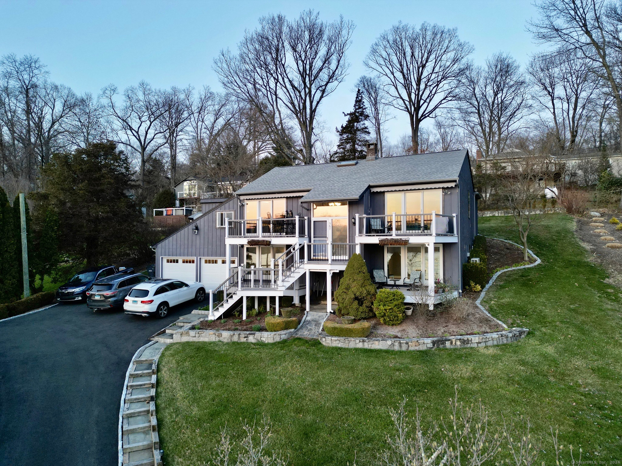 Welcome to this stunning waterfront home in the prestigious Candlewood Lake Club just 90 min from NYC. This modern residence is perfect for those seeking a tranquil lakeside retreat. The spacious common area features two adjoining living room spaces, each with sliders leading to their own deck whose hillside panoramic views provide beautiful vistas of the lake, year-round. The sleek, updated kitchen and dining area just off these living areas also open to a deck on the far side of the home, perfect for hosting large gatherings or drinks after a round of golf. The main level, primary bedroom boasts an en-suite bathroom and generous walk-in closet. The two additional bedrooms both feature walls of glass that open to their own private deck spaces. Lakeside, the screened-in gazebo, complete with fridge and electrical, offers plenty of opportunity for outdoor activities and al fresco dining. The additional stone patio, and lakeside deck provides ample space for overflow or a quiet evening by the water's edge. The firepit area and duel docks complete this waterfront package and give you the perfect place to make your vacation home dreams a reality.  Conveniently located in The Candlewood Lake Club, this home also gains you access to a range of resort-style amenities including club house events, pickleball, private beach, resident only 9 hole golf course, tennis courts, and a variety of activities for young and old alike. Embrace the waterfront lifestyle!