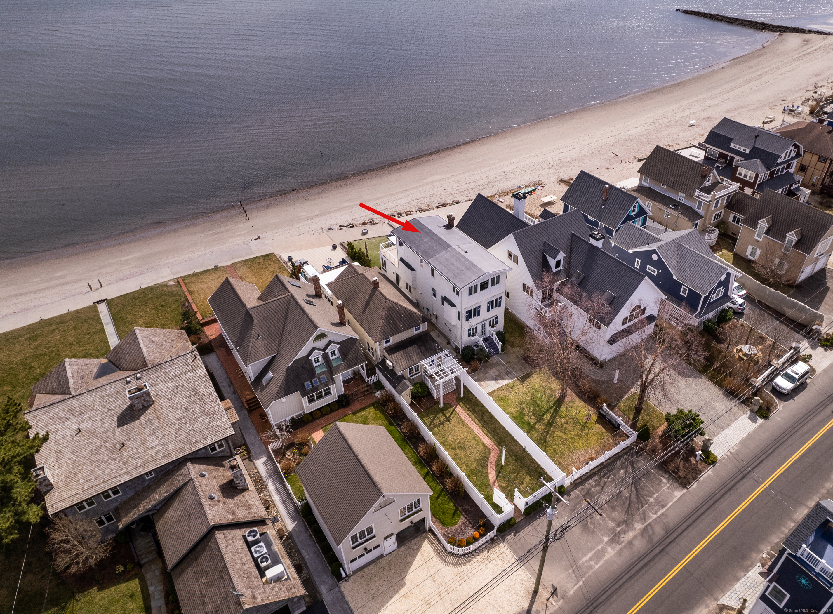 Welcome to this captivating 4-bedroom beachfront Colonial nestled along Fairfield's coveted waterfront. Originally a quaint beach cottage, this home has been thoughtfully expanded and renovated, offering prime access to soft sandy beaches and breathtaking sunsets.  Step outside onto the patio to immerse yourself in panoramic Long Island Sound views, complete with a sea wall. Adorned with a charming white shingled exterior and whimsical blue shutters, this residence is surrounded by an established perennial landscape. Inside, the kitchen boasts a tiled floor, butcher block station, and breakfast bar opening into a spacious dining area. Relax in the bright living room with a cozy gas fireplace or enjoy beachfront views from the sun room.  Upstairs, the master bedroom features a huge private balcony with lighting, overlooking the tranquil beach. With 4 generously-sized bedrooms spread across the second and third floors, this home offers ample space for families and versatile home office setups. For added convenience, a second-floor laundry room streamlines chores. Outdoor living is enhanced with an additional outdoor shower. Wainscot ceilings, accent walls, and bamboo floors throughout add coastal charm. Parking is accommodated for three cars in the paved driveway, with additional property on the creekside. Inquire about possible ideas for a carport/garage. Don't miss the chance to make this waterfront sanctuary your own. Experience coastal living at its best .