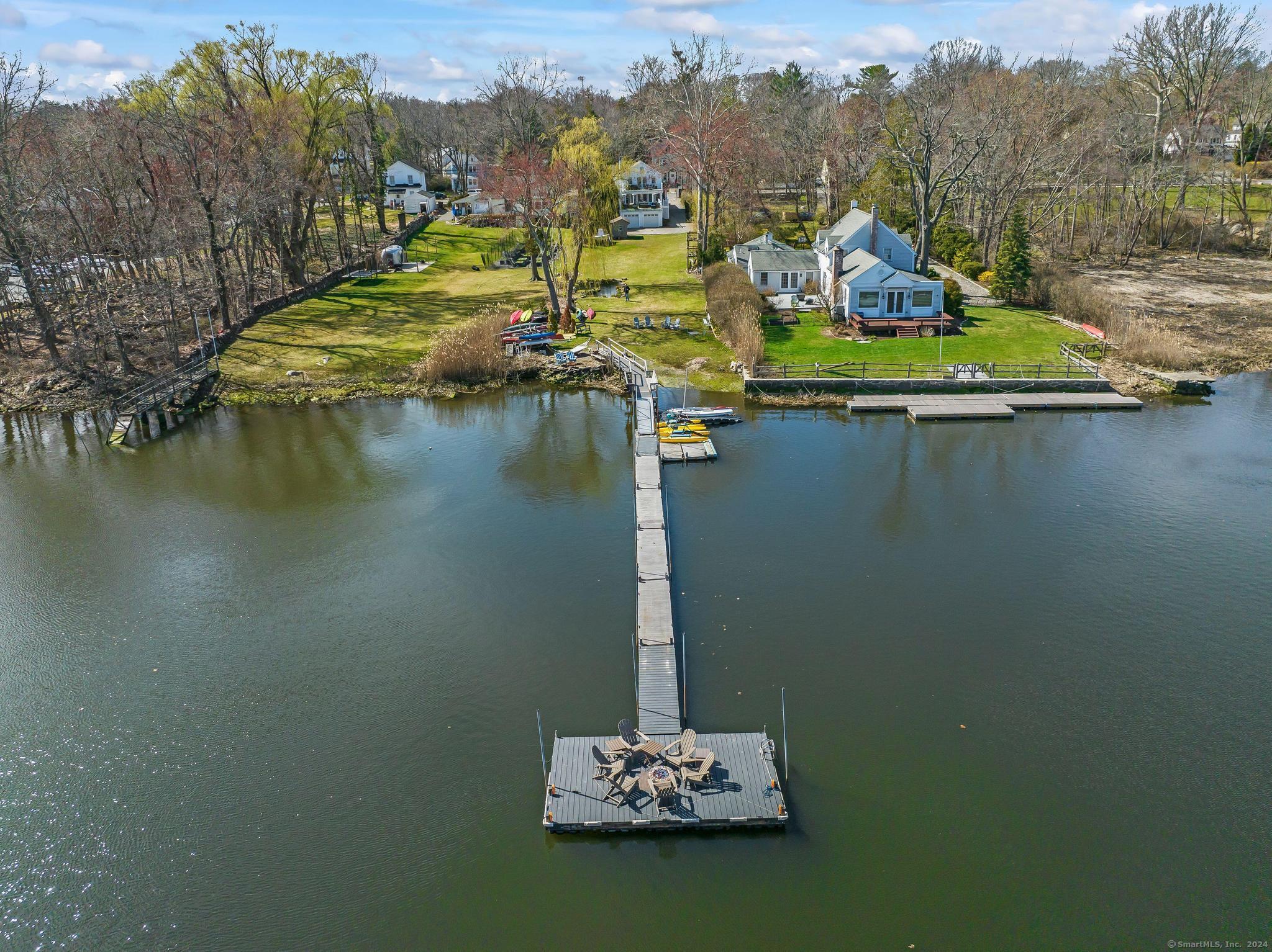 Lovely 2900++ sf waterfront on .49 flat acres sitting on the Saugatuck River. Includes large extended dock, pond and wonderful home with over 50' of water frontage and glass tiered decks. Close to Metro. Enjoy an estate with scenic channel views of rowers gliding along in sync heading to the L.I. Sound, A large yard/dock can anchor several boats. Enjoy Duck/Koi pond and big yard. Designed to combine old with new includes 4 bedrooms & 4 baths. Circa 1860 facade joins a modern bright floorplan with glass wall to the great tiered decks. The Primary en Suite bedroom boasts cathedral 14' ceilings - extensive views of the River. walk out veranda, seating, hot tub and log or gas fireplace for a quiet evenings. Nursery or office. Kitchen has a gas stove and opens to the living & dining area. A wonderful large brick fireplace ads ambiance & French doors open to covered deck. Romantic private dining room and parlor/library. Guest/Au Pair quarters & bath. Bonus finished lower level has 4rth bedroom, sitting area, bath & exit. Dock is situated for motor boat, kayaks & dock parties with ample room to BBQ or relax in the deck hot tub. This farmhouse has built to meet today's modern lifestyle while keeping the integrity of its Westport History. Large 2 car garage & work shop. Very close distance to all - Golf, Tennis, Rowing, TOP restaurants, Compo Beach and Longshore Club. Train 5 minutes. No flood Ins. Just move in. Summer oasis awaits. By Appointment.