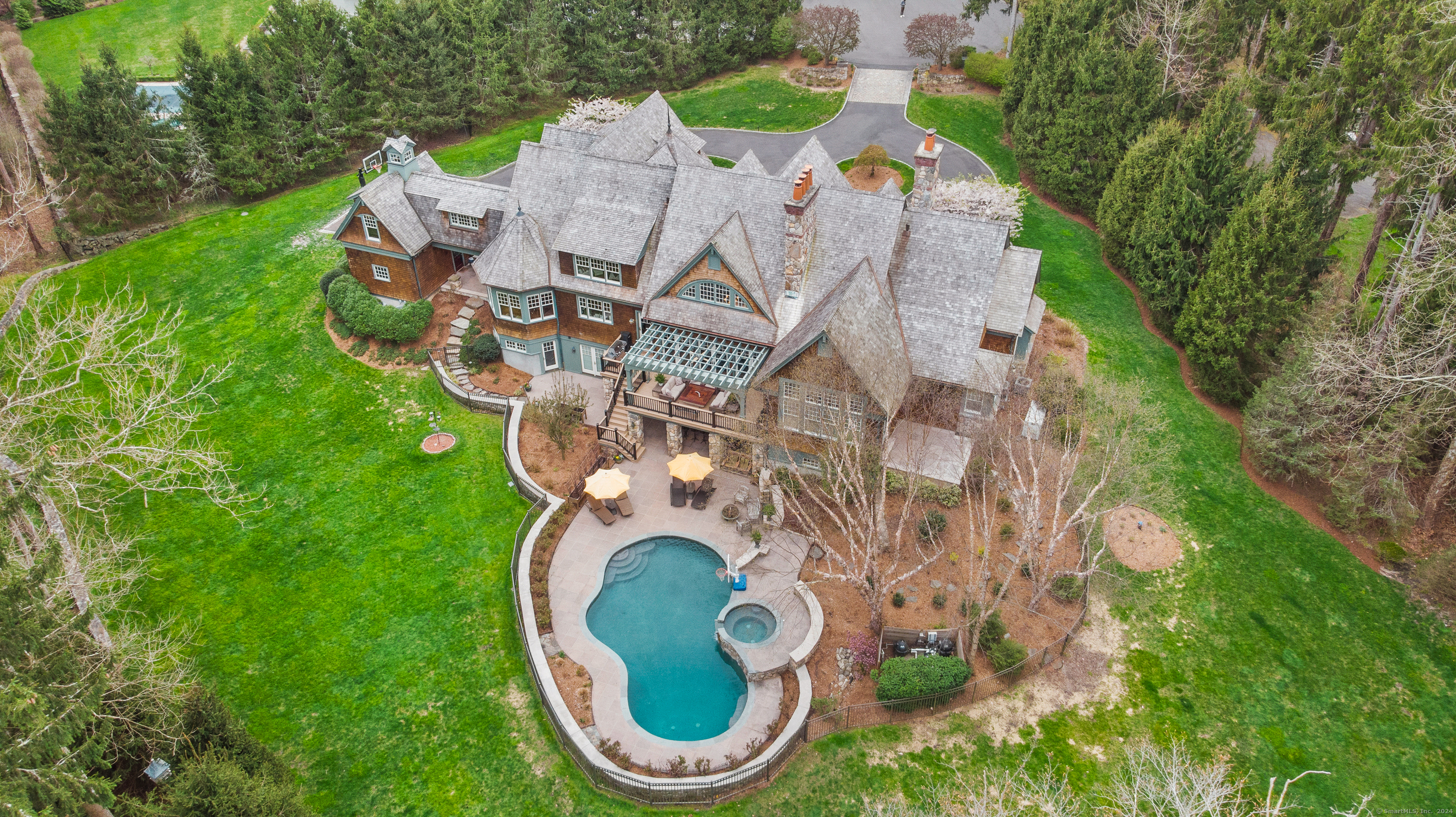 This Custom Built Adirondack Estate boasts over 10,000 incredible square feet of living space, perfect for entertaining, working, playing and relaxation. This one-owner cedar shake masterpiece showcases exceptional workmanship crafted with the finest materials which is evident upon arriving at 6 Pan Handle Lane. The cobblestone entrance leads to a circular drive welcoming you onto the beautiful 2.51 acre property. Enter the two-story foyer and take in all of the elegance. You will be captivated by the seamless flow to the living room, dining room and the two-story open great room enhanced with a stone fireplace and French doors to the deck and pergola, bringing the outdoors in. The chef's kitchen offers high-end appliances including three ovens, an oversized island and opens to a breakfast room accented with a brushed nickel ceiling. The regal first-floor office is a must-see, adjacent to the exquisite Primary Bedroom Suite with a fireplace, oversized walk-in closet, luxurious bath with radiant heated marble and onyx floors and an outdoor patio, allowing you to enjoy the beauty of your private yard.
