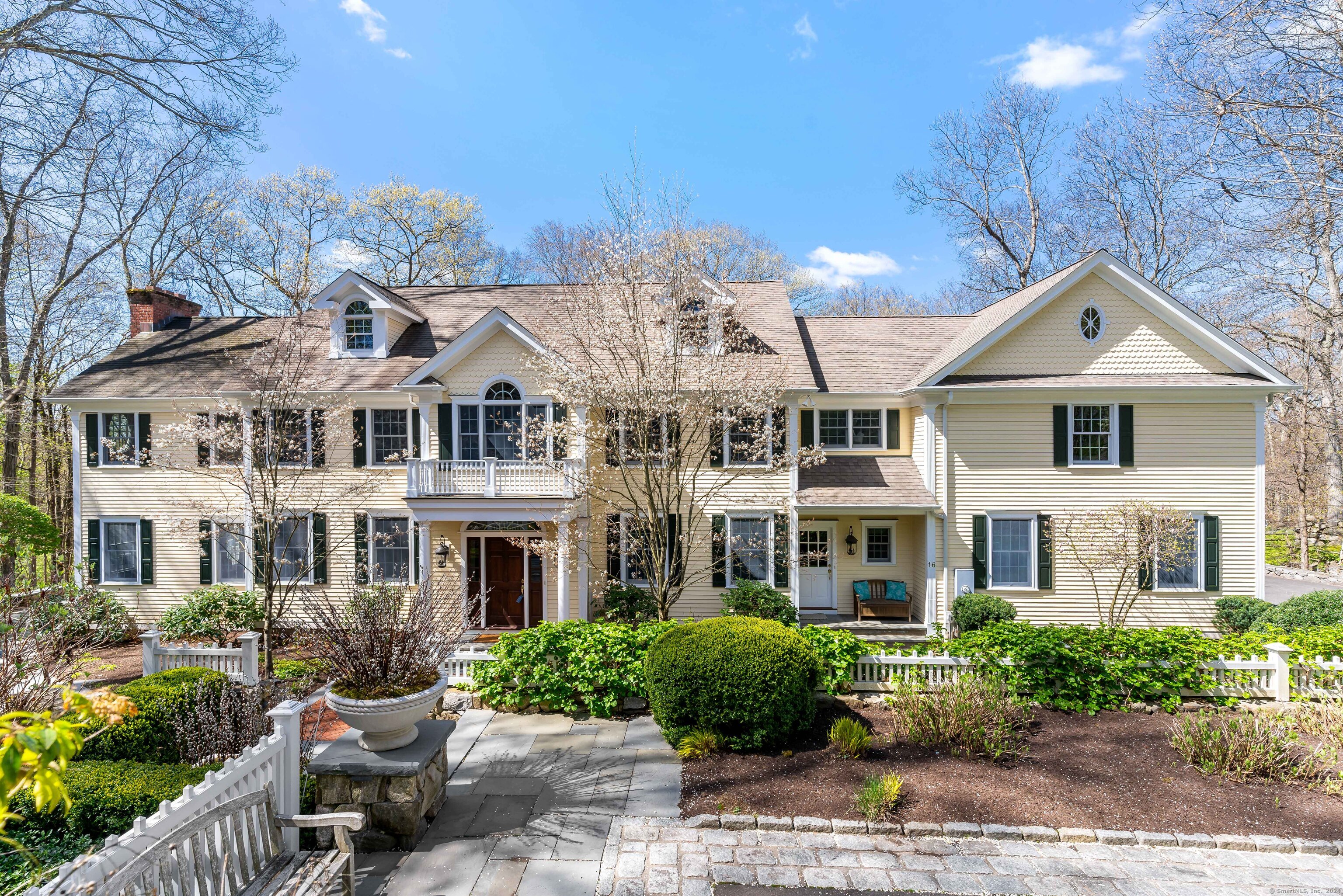 Just five minutes away from the cherished Graybarns in New Canaan, the epitome of sophistication is found in this light-filled, stately colonial in South Wilton. PUBLIC WATER and showstopping lower level are just two of the special amenities. Located in a private enclave just minutes from both New Canaan, Wilton and South Norwalk town and trains, this "levelled up" home offers both neighborhood and privacy, overlooking the woods. The kitchen includes beveled Quartzite countertops, Wolf induction cooktop, beverage cooler, warming drawer, plentiful storage, high-end Bremtown 700 series custom cabinets and a custom built burlwood entertainment and storage cabinet. The adjacent sun-filled family room with stone fireplace includes entrance to the upper patio, with built-in kitchen. Library with custom cabinetry and 120-bottle Sub-Zero wine cooler is the perfect place to solve the problems of the world over a fine wine. The 1st floor office provides a quiet space for funding the problem solving! The Primary Suite includes 10' ceilings and separate grand sitting room with beams, fireplace, ambient lighting, full bath and walk-in closet--a true sanctuary. Four additional bedrooms on the second floor and two full baths provide space for family and friends. The walk-out lower level is a stunner-with large center island with leathered granite countertops, conv/micro oven, dishwasher, wine cooler and ice maker. The owners invested heavily in the oversized patios and landscaping. A gem!