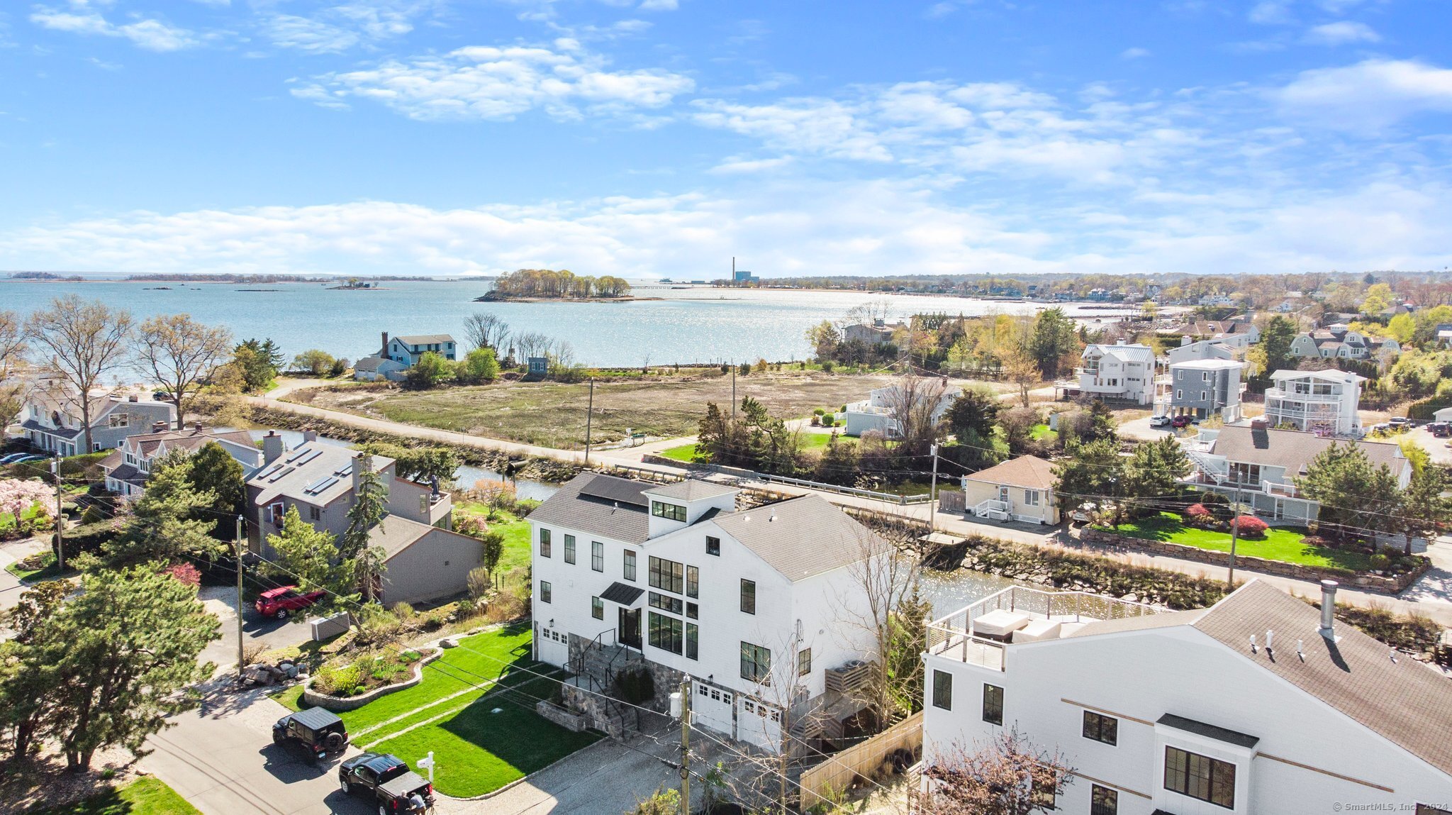 PREPARE TO BE WOWED by the "to-die-for" water views throughout this modern & elegant 4 bdrm, 3.5 bath home. This stunning residence designed and built by the current residents in 2018, spans 3,271 sq ft and is situated on a generous 9,583 square foot lot. Upon entering, you are greeted by an abundance of natural light that enhances the sleek & sophisticated interior. Wonderful flow w/open floor plan connecting living, dining, & kitchen areas, creating an ideal space for entertaining and everyday living. Double sliding glass doors open completely to seamlessly blend indoor & outdoor living. The gourmet kitchen features top-of-the-line appliances, custom cabinetry, & large center island, perfect for culinary enthusiasts. The primary bedroom suite is a tranquil retreat, boasting ample space, a luxurious en-suite bathroom w/radiant heated floors, walk-in closets and a deck to take in the exquisite sunrises & sunsets. A Jr bedroom suite plus 2 additional bdrms offer flexibility for family & guests.The home also provides an office, gym, boat dock, solar panels & full house generator, outdoor shower & even a Kegerator. The well-appointed bathrooms are designed w/modern fixtures and finishes, providing a spa-like experience. Step outside to the private outdoor oasis, complete with spacious rooftop terrace, patio, decks, lush landscaping, & plenty of space for al fresco dining & relaxation. Enjoy a Saugatuck Island lifestyle where you'll feel like you're on a full-time Staycation!!