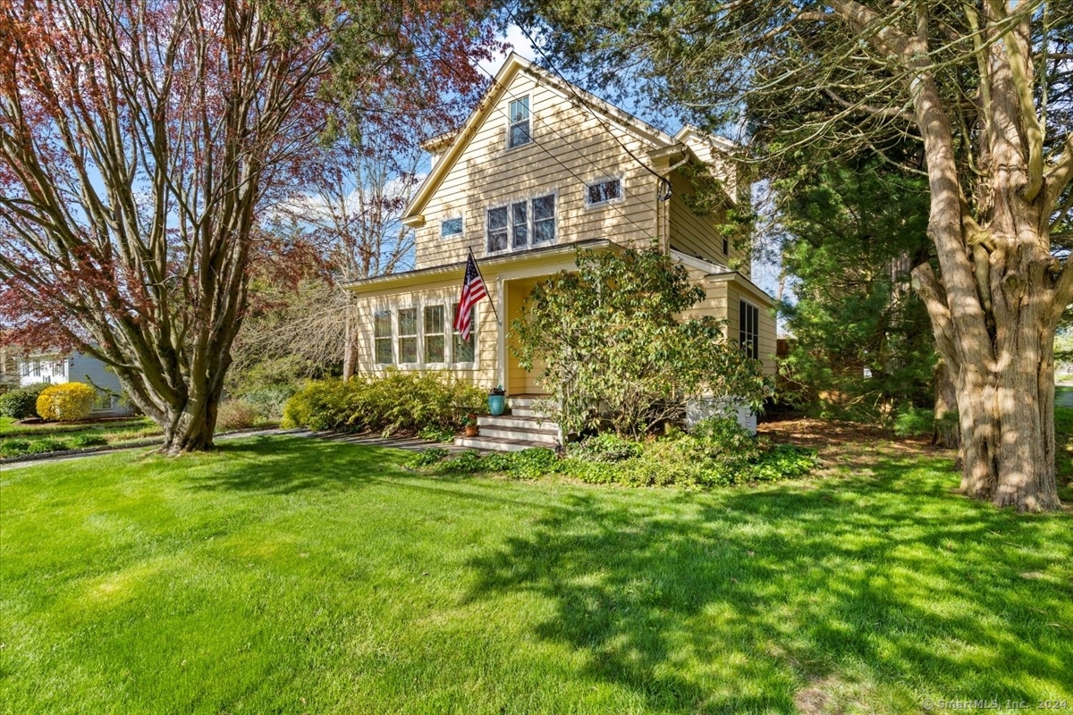 Charming 3-bedroom Colonial has 2.5 baths on 0.20-acre lot with peekaboo seasonal water views! This spacious Mystic home has 2,720 sf with hardwood flooring and impressive architecture on display throughout the home. Upon entering the home, you are greeted by the small intimate sunroom that leads to the open living room and displays a beautiful, crafted wood doorway to the dining room and flows into the bright and cheerful eat-in kitchen. It offers stainless steel appliances and a breakfast bar for casual dining. The main level showcases a primary bedroom with skylights to allow natural light to filter through and has a large private full bath. A secondary primary bedroom is featured on the upper level and includes a full bath and walk-in closet with a laundry area for convenience. Both primary baths have radiant floors! A sizeable family room and office space with a beamed ceiling and knotty pine walls rounds out the second level. For ultimate privacy, you will love the third-floor bedroom that features a window seat for those quiet, meditative moments, a skylight, a half bath, and a walk-in closet with built-in shelving. The home is complete with an automatic generator, central air, several arched entryways, full basement, and a detached garage. Leave the outside world behind and retreat to the backyard with its attractive deck that opens to a lovely brick patio and array of garden areas whereby you will enjoy the sounds of nature all around you.