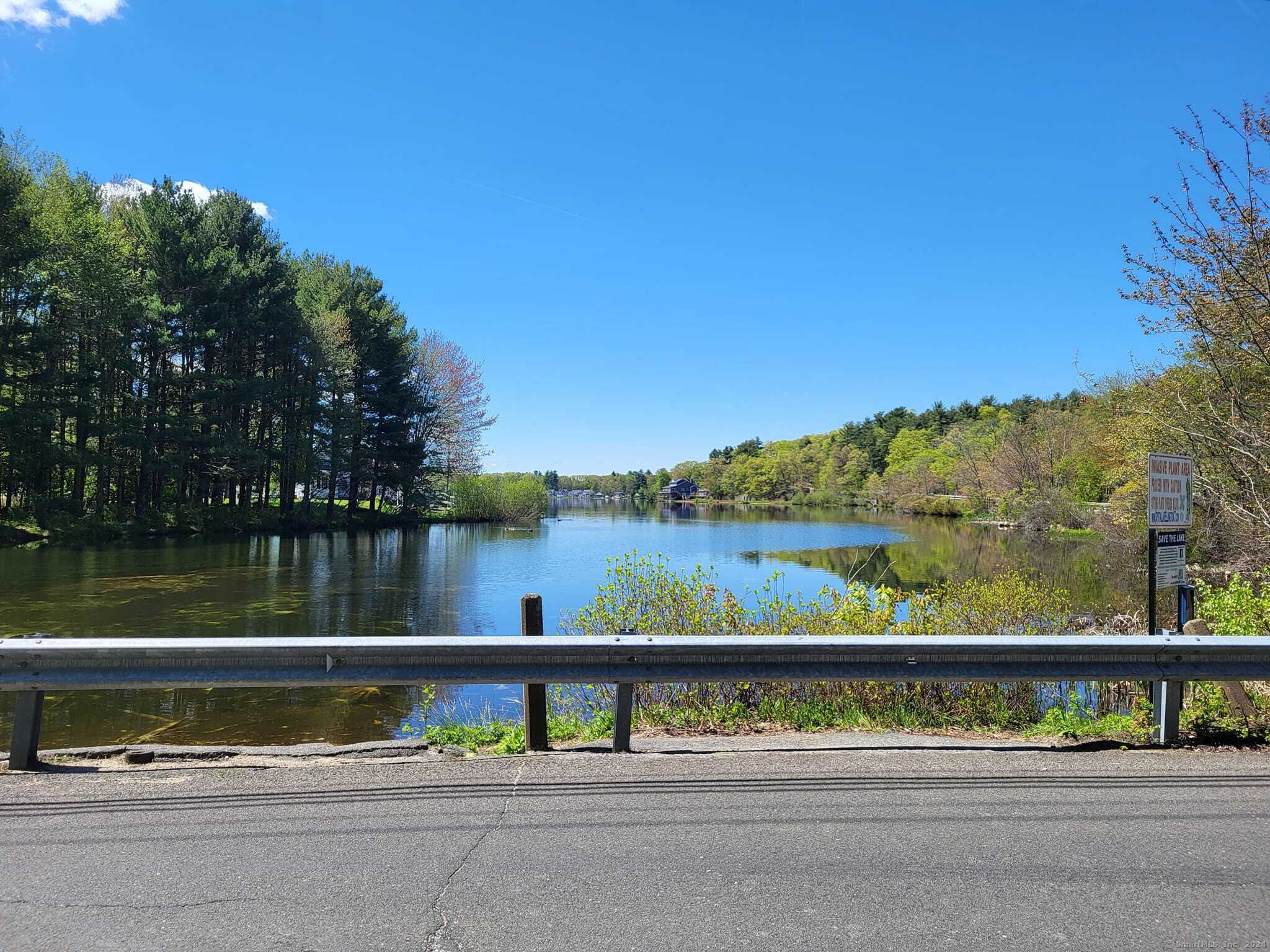 Water views! Located across the street from Crystal Lake, some clearing & a 2 story home with 2nd story deck could have unencumbered views overlooking the lake, views (and sounds) of the waterfall at the spillway & Crystal Lake Brook which flows along the on the west side of the property. It has an existing parking lot that fits 8 single line standard 9' wide parking spaces. A public boat ramp is just down the road. The 44' deep lake offers waterskiing, swimming, trout and bass fishing. The Ellington town beach is at the south end of the lake but sometimes folks will jump in at this north cove end of the lake & swim over to a sand bar to keep cool. Road frontage is 574', 383' on Crystal Lake Rd (RT 30) & 191' on Conklin. To locate, lot is next to house 161 Conklin Rd. Lot has a 2007 class A-2 survey, topo & wetlands delineation by a certified soils scientist, location all surveyed out (inward facing black triangles on the map photo). Some up & down topography should grade out fine with an approved engineer's site plan, needed in this zone anyway. 26 minutes to Main St Hartford