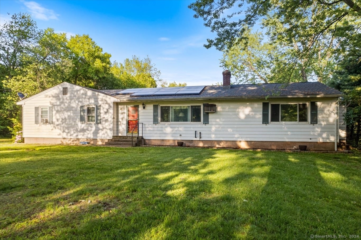 This ranch-style home, built in 1962 and cherished by a single family, offers a blend of spacious living and functional separation ideal for multi-generational living or hosting guests. The main house boasts three bedrooms, including a primary suite with a half bath and washer and dryer hookups, an inviting eat-in kitchen, and a cozy living room with a fireplace. A covered deck overlooks 1.15 acres of cleared land, featuring an above-ground pool and ample parking alongside the two garage spaces. Solar panels enhance energy efficiency, while a recently installed roof ensures durability. Storage abounds in the basement, complete with a workshop area. Additionally, the property includes an in-law apartment with one bedroom, one bath, a kitchen, and a living room, offering privacy with its own access points and septic system. Be sure to schedule a walk-through today!