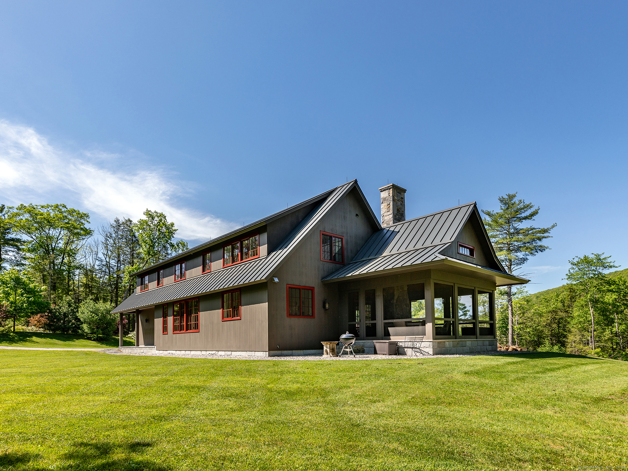 Welcome to Ledge House in charming FALLS VILLAGE, CT. Gracious living on the top of Canaan Mountain adjacent to the 6, 000-acre Great Mountain and the Housatonic State Forest. Gorgeous light-filled, craftsman-built home on the edge of Wangum Lake Brook with views of Stoneman Mountain. Meticulous artisanship throughout utilizing the highest quality materials and finishes. The property is situated at an elevation over 1, 300 feet on the mountain road from Falls Village to Norfolk and just fifteen minutes to charming shops in both. This cedar-clad country house features a high ceilinged living room with beautiful white oak floors and custom built-in bookshelves and with massive fireplace opening onto magnificent screen porch with it's own stone fireplace. The chef's kitchen and pantry features bar height granite counter-tops, a farmhouse sink and high-end appliances. The elegant staircase leads to the second floor with a primary bedroom suite with a pair of walk-in closets, two guest bedrooms with ensuite bath, a laundry room, a cozy landing with study, an office with barn door, all with stunning mountain views. The primary bath features a large shower and oversized cast iron bathtub with radiant floor heating. Other features include a two-car garage, a whole house generator and two gigabit fiber optic internet. Enjoy stylish mountaintop living with an adjacent babbling brook just 2 hours from NYC and only 12 minutes to Mohawk Mountain ski resort.