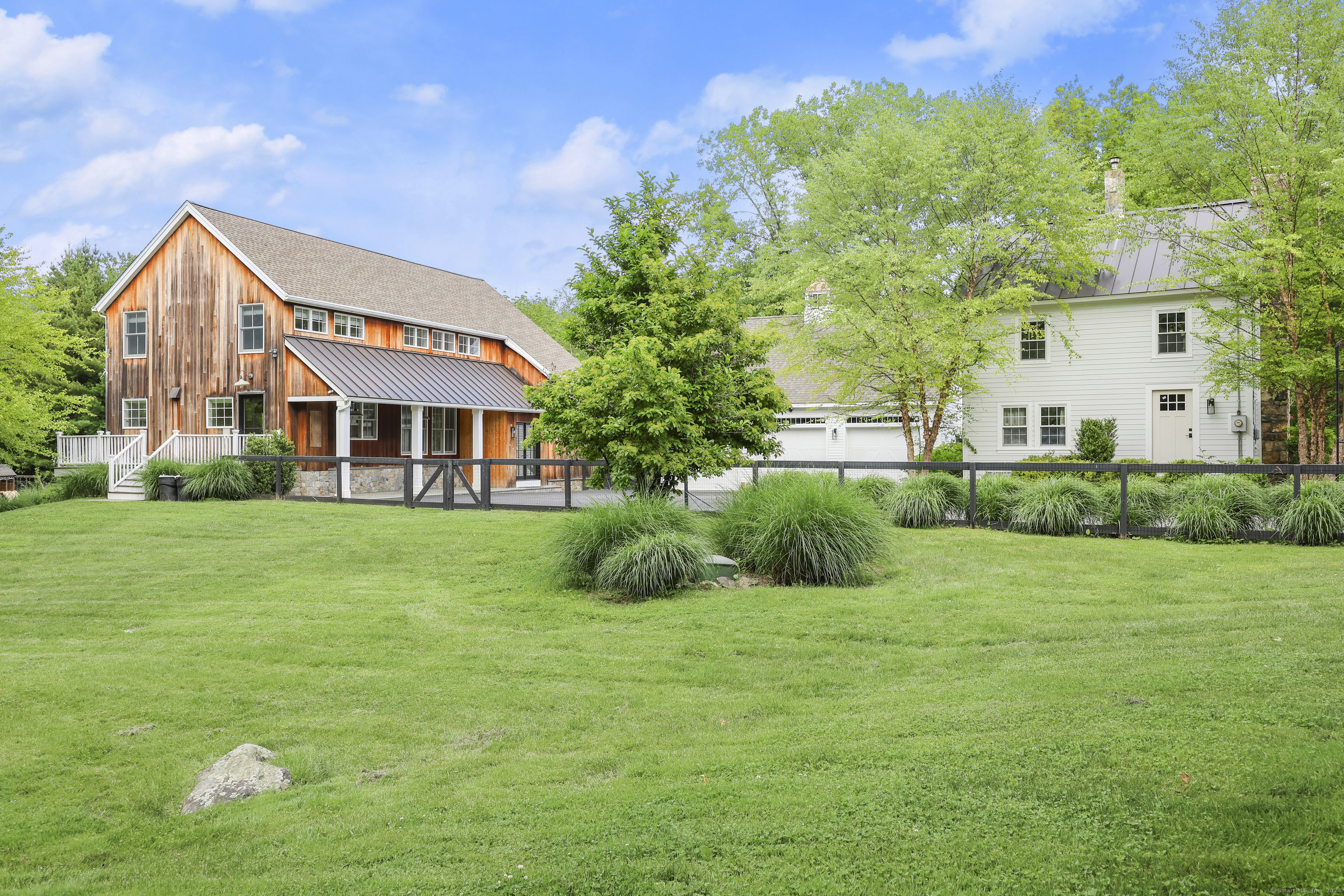Welcome home to this gorgeous turn-key converted barn set on 1.55 acres close to downtown Ridgefield! The property also features a 3-car garage with large studio above and a 1, 480 sq ft guest house. The main house features an open floor plan ideal for everyday living and entertaining with walls of glass for abundant natural light. Additional highlights are 11 ft ceilings, white oak flooring throughout, high-end lighting fixtures, and central air. The living room features a fireplace and is open to the dining room with sliders to the rear patio and overlooks the beautiful property. The heart of the home is the chefs eat-in kitchen with Carrara marble counter tops, a wall of built-ins, large center island, and glass door to deck. Upstairs find the primary bedroom with beamed cathedral ceiling, walk-in closet, and updated ensuite bathroom with Dolomite Italian Marble. The upper-level features two additional good-sized bedrooms. The finished lower level provides a spacious family room with engineered wood flooring and excellent storage space. The professionally landscaped property offers many areas to relax and enjoy the peaceful setting and is completely fenced with gated entry. Additionally, the property features a spacious studio above the garage great for a home office, and a guest house ideal for family or a rental. Come and see this move-in ready home today!