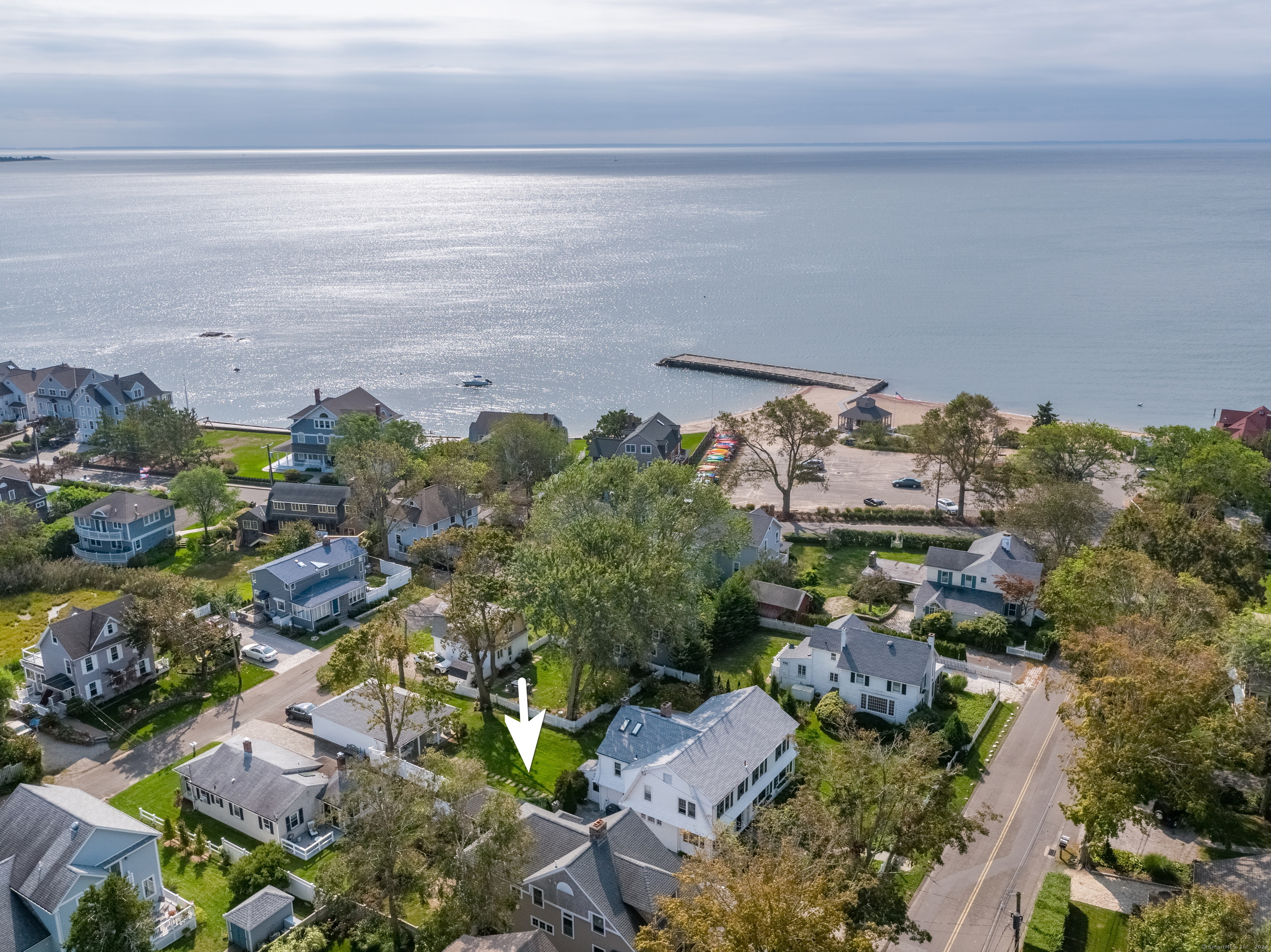 ATTENTION BEACH LOVERS! Move right in and enjoy summer at the beach! Located just four homes north of East Wharf Beach In the heart of the Madison waterfront, this 1947 classic with 4 bedrooms and 3 full baths has been completely updated while retaining its original charm. Set back from the street behind a fenced front yard, a large screened front porch with stone columns provides the perfect spot for morning coffee or evening drinks. Enter the living room with its impressive stone fireplace which flows into an open kitchen with stainless steel appliances, counter seating for six plus a dining area and a family room. There are beautiful, original Douglas fir floors throughout the first floor. Also on this floor is a laundry and a full bath. A back deck leads to a stone patio and grassy yard. Upstairs are four bedrooms, three of which share a family bath. The primary bedroom has an ensuite bath, a walk-in closet and a sleeping porch. A large shed provides excellent storage space.