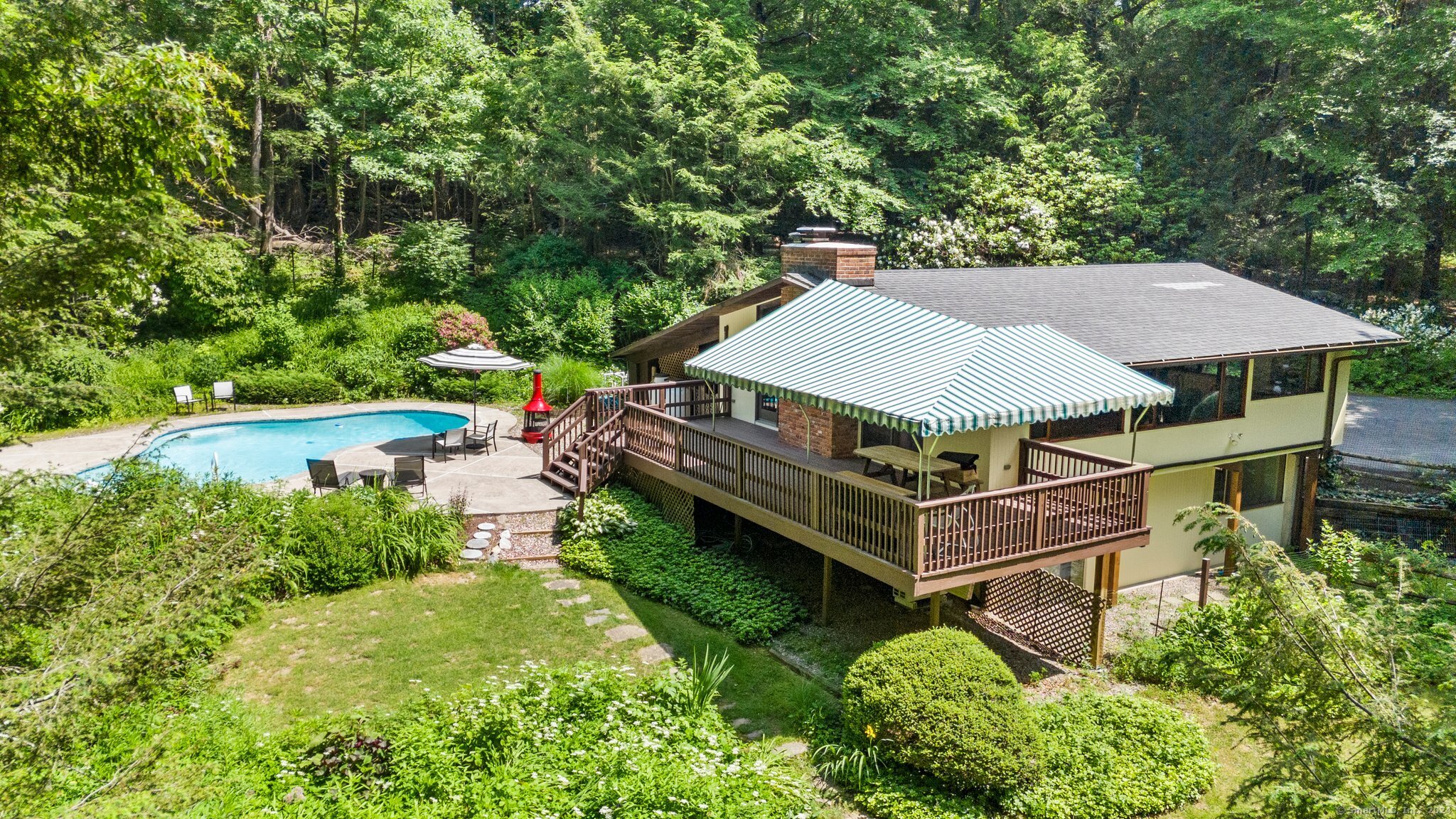 Move-in ready - just in time for summer! This home offers tranquility and privacy with 1, 616SF on 2.68 acres and a pool. Recently renovated in 2022, close to the Ridgefield line in West Redding with easy access to Rt 7 & 84 yet tucked into the woods. The main level of this light-filled Deck House was fully renovated in 2022, ensuring views of the property with open concept; top-of-the-line finishes, including a Chef's kitchen featuring a Wolf induction range, undercounter oven, a 140 bottle capacity wine fridge, Bosch refrigerator, Electrolux dishwasher, custom granite countertops, counter seating, pendant lights and premium cabinets. New oak hardwood floors, mahogany trim, new custom mahogany windows and new Andersen sliding glass doors finish out the main level, which opens directly onto the deck. The open concept floor plan allows flexible space for dining and living room areas, with a wood-burning fireplace as a central feature. Spray-in foam insulation on the main level. The lower level carries three bright bedrooms and a bathroom, including laundry area. Ductless air conditioning was installed on both levels in 2023, can also be used for heat. Whole house generator. Enjoy the beauty of the perennial gardens and relaxing around and in the gunite pool! The interior perimeter of the yard is fenced, making it ideal for dog owners. Bird lovers will enjoy listening to nature at this peaceful oasis - perfect as a primary, secondary or retirement residence! Agent/owner