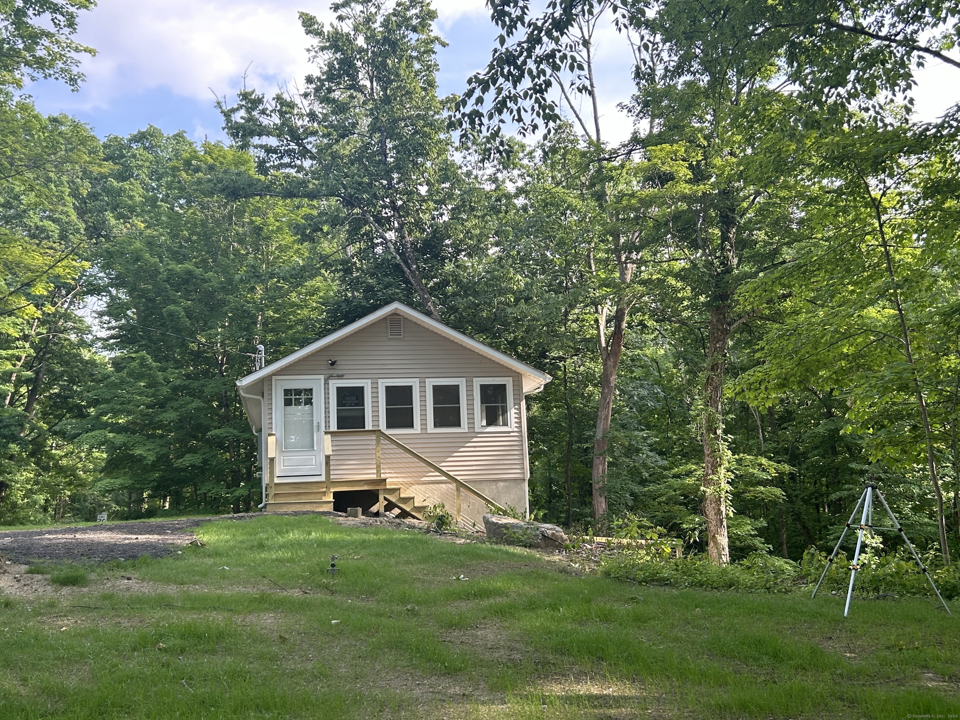 This charming lake cottage has undergone a stunning transformation, turning it into a delightful getaway that's perfect any time of year. Originally a modest shell, it now shines as a pearl, boasting one bedroom and 1.5 baths. On the upper level, you'll find a fully equipped kitchen with brand new appliances, a fresh bathroom with a shower, new windows throughout, and a comfortably sized bedroom. A spiral staircase leads you down to the living area, which opens onto a fantastic deck overlooking a tranquil brook and offering views of Silver Lake. The lower level is equipped with a convenient half bath and a laundry room for added convenience. Nearby, you'll find amenities such as a community boat launch and a town beach, perfect for enjoying water activities like canoeing, kayaking, or swimming at Sharon Town Beach just a short distance away. The location also offers easy access to a variety of attractions including restaurants, a nearby train station, rail trails for outdoor activities, local wineries, and the Sharon Playhouse for entertainment. Whether you're seeking a peaceful retreat or a place to enjoy outdoor adventures and local entertainment, this cottage offers the best of both worlds in a picturesque setting.