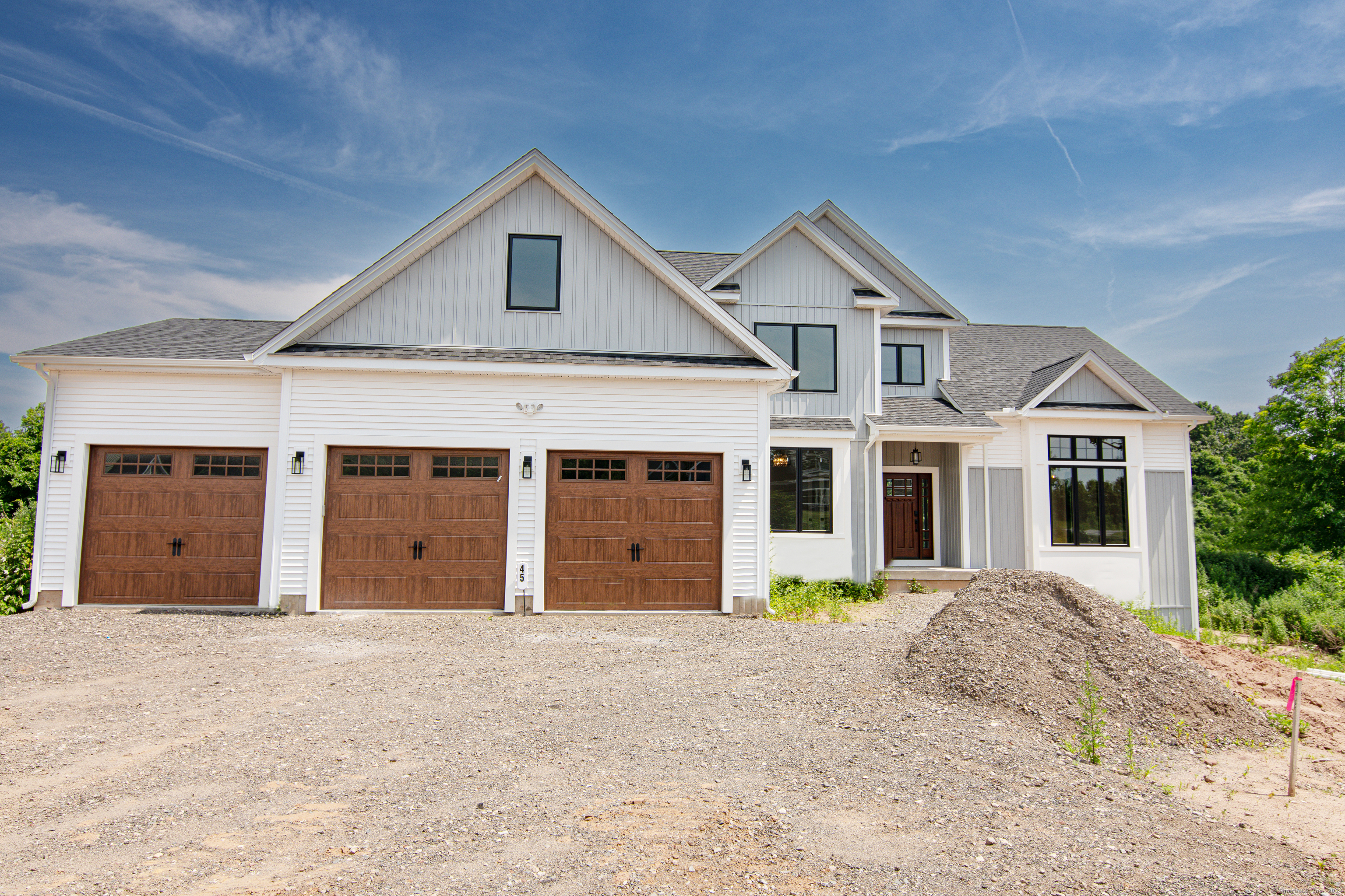 Presenting an exquisite, one-of-a-kind Modern Colonial Farmhouse that seamlessly combines elegance and functionality. This custom-built residence features a sophisticated open-concept floor plan and high-end finishes throughout. The home showcases a stunning blend of white and dove gray vinyl siding, complemented by high-quality Marvin wooden casement windows, creating a clean and refined exterior. First floor boasts impressive 12-foot ceilings in the living and dining areas, framed by oversized windows that flood the spaces with natural light. Gourmet kitchen is designed for both style and functionality, featuring a large island, an oversized 36 cooktop, and a wine refrigerator integrated into the island. Quartz countertops and a marble tile backsplash add a touch of luxury.The first-floor master bedroom includes a spacious walk-in closet and a master bath with a dual-sink vanity, a standalone tub, a roomy glass shower, and a marble-tiled heated floor for ultimate comfort. A compact office/study area is conveniently located off the dining room. The oversized, partially covered back porch is equipped with spotlights, a fan, and an outlet for a TV, perfect for outdoor relaxation and entertainment. The second floor features a large bonus/recreation/game room and three additional bedrooms. One of these bedrooms includes a private bathroom and a walk-in closet, making it an ideal guest room. This home offers an unparalleled living experience with its thoughtful design...