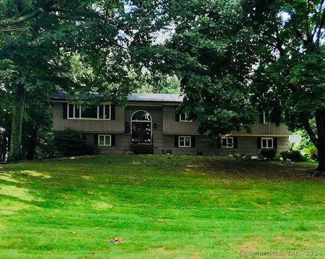 Nestled in the beautiful Tashua neighborhood, this splendid Hi Ranch boasts over 3, 000 square feet of living space. Step into a charming foyer with marble floors and a graceful chandelier. The main level houses four bedrooms and two full baths, complemented by a living room with large windows, recessed lighting, black-stained wood floors, and a fireplace updated with sleek black tiles. The living room seamlessly transitions into a formal dining area and kitchen equipped with newer solid core countertops, tile backsplash, vinyl plank flooring, and stainless steel appliances. Adjacent to the kitchen is a light-bathed sunroom, an inviting retreat that directly accesses the deck and beautiful outdoor space. The lower level unfolds into an additional 1, 100 square feet of finished area, featuring a cozy family room with a fireplace and new luxury vinyl flooring, a fifth bedroom currently used as a media/theater room, with new plush carpeting, the 3rd full bathroom, and a supplementary kitchen, ideal for accommodating family gatherings, also with new luxury vinyl flooring. Additional recent upgrades include a 2020 roof with gutters/gutter guards, central air conditioning, Smart dimming switches and recessed lighting, interior paint on walls and trim, and newer septic tank. The property spans nearly one acre and includes a two-car garage, offering both privacy and convenience. **Exterior including shutte has been freshly painted, deck power washed and painted. **