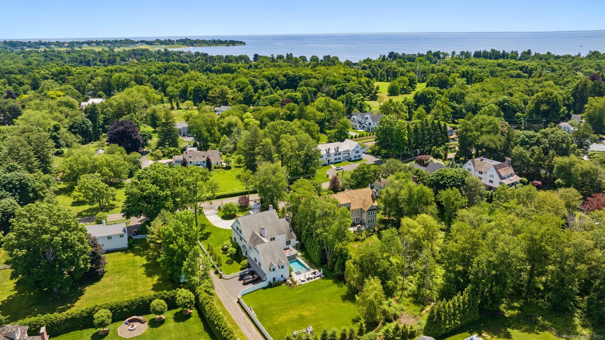 Incredibly located in Greens Farms, the prized estate setting of Westport, this customized luxury home showcases an array of thoughtful and luxurious upgrades at every turn. This home's signature grandeur begins with the circular driveway, leading to an impressive double-door entry that leads to a soaring foyer w/herringbone-patterned wood floor. From here, the impressive proportions of this home are apparent - as are the fine details and distinctive finishes that define each space. The living rm w/fpl & dining rm w/butler's pantry are both entertaining-sized. The generous family rm has a wall of French doors to the terrace, stone fpl & leads to the showstopping gourmet kitchen w/fpl, lrg island, full suite of gourmet appliances include Viking range, Sub Zero all-refrig/all-frz, wine chiller, beverage drawers, speed oven & sunny breakfast area w/ bay window. An excellent mud rm w/vast storage, 2nd laundry & a full bath for the pool leads to the 3 car gar. An uncommon main flr guest suite plus a very generous office complete the first level. Upstairs, the gallery hall leads to the sumptuous primary suite, a luxe retreat w/king-sized BR, built-ins, vast walk-in closet, balcony, incredible bath w/frameless steam shower, soaking tub, fine millwork. Each BR is a private suite w/full bth. Amazing bonus spaces incl the lrg 2nd flr rec/play rm, fin 3rd flr and fin LL. The scenic pool has a spa, waterfall & auto cover. Level backyard. Walk to Greens Farms train, beaches.