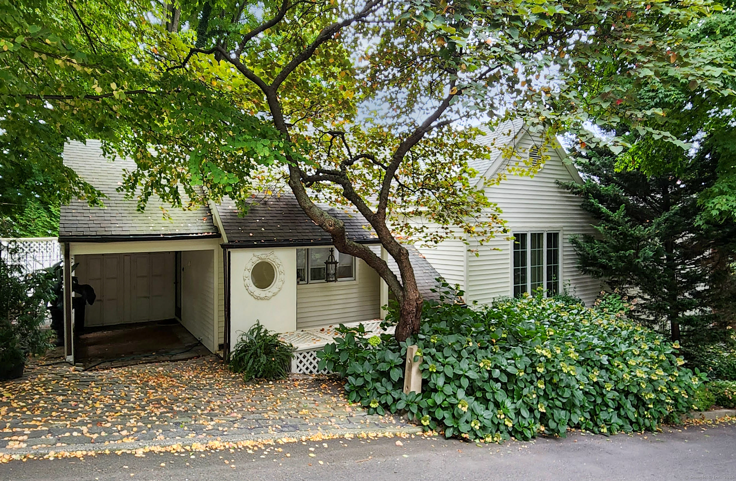 The tranquil entrance features a stunning 18th-century door, archway, and brick floor, setting the tone for a design masterpiece that blends modern amenities with historic elegance. The great room boasts a 10-foot cathedral ceiling with an 18th-century arch, a mantel, and fireplace, all enhanced by antique wide plank wood floors, making it perfect for entertaining. The kitchen includes skylights, a pantry, and laundry, along with a convection oven, microwave, five gas burners, dishwasher, and instant hot water. The dining room features a light-filled window and an 18th-century fireplace. With three bedrooms and three full baths, including a whirlpool and shower, the home also includes a loft/library on the mezzanine for quiet retreat. A 1, 514-square-foot patio with a beautiful garden can be accessed from the master bedroom or the grand glass French doors in the great room. Located in Historic Southport village, it's just a short walk to the train, restaurants, and beach.