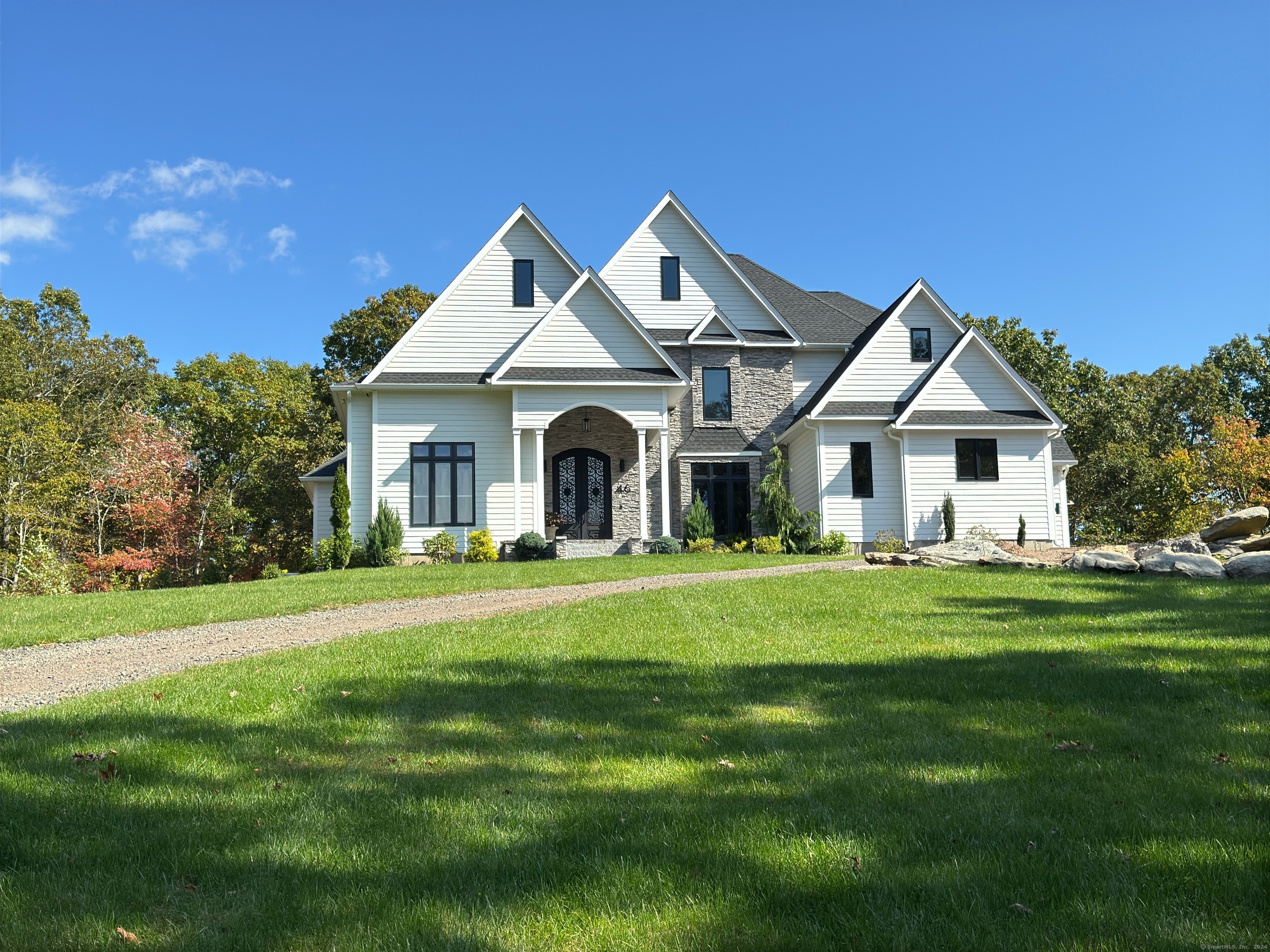 Welcome to 46 Signal Ridge Road, a stunning French-style home set on a tranquil 6.74-acre lot at the end of a peaceful cul-de-sac in South Glastonbury. This remarkable residence offers approximately 5, 000 square feet of luxurious living space, featuring an open floor plan that seamlessly connects the spacious living areas-perfect for modern living and entertaining. With four generously sized bedrooms and three full baths, plus a convenient half bath, comfort and style are prioritized throughout. Four inviting fireplaces create warm spaces for family gatherings, and the grand 10-foot custom wrought iron front door makes a striking first impression. Step outside to a large outdoor entertainment area with a beautifully crafted stone patio and a refreshing saltwater pool, ideal for summer relaxation and hosting guests. A reliable house generator ensures peace of mind in any situation. Built in 2021, this home combines contemporary design with timeless elegance. The three-car attached garage provides ample space for vehicles and storage, while the 3, 100-square-foot walk-out basement, pre-plumbed for a bathroom, offers additional potential. Enjoy modern conveniences like an Elkay in-wall water fountain, 8-foot interior doors on the first floor, and a hardwired exterior security camera system. The Blaze Luxury exterior grill enhances your outdoor cooking experience. Experience the perfect blend of privacy and luxury at 46 Signal Ridge Road.