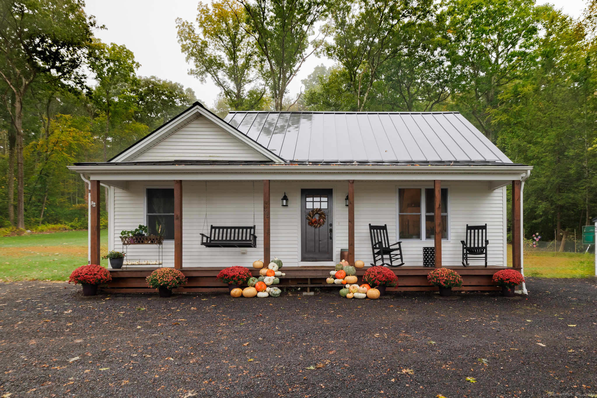 This newly built modern country ranch offers single level living at its best in the beautiful town of Litchfield! From the dream front porch for sipping your morning coffee, to enjoying nights around the firepit on the beautiful rear patio, this house offers plenty of outdoor space with almost 2 acres and a detached two car garage. Inside you'll find a spacious kitchen that will please the cook in the family with a large island, granite countertops, deep farmhouse sink, and a gas range with a beautiful exhaust hood. French doors from the kitchen lead directly out to the rear patio blending the indoor and outdoor spaces, perfect for enjoying dinners with guests. The open concept floor plan with hardwood flooring throughout and vaulted ceilings gives the home a modern feeling while the white shiplap walls keep the balance of a charming country home. The laundry room is conveniently located on the main level making this a perfect home for those looking to downsize with virtually no stairs. The primary bedroom features a walk-in closet and has a delightful on suite bath featuring double sinks and a walk-in shower enclosed in glass, both accessed by sliding barn doors. The two remaining bedrooms share the second full bath with plenty of space for everyone. This 7-year-old home has a 200 amp electrical panel, efficient propane heating system, and central air throughout. To top it all off is the amazing black standing seam metal roof that looks great and will last forever!