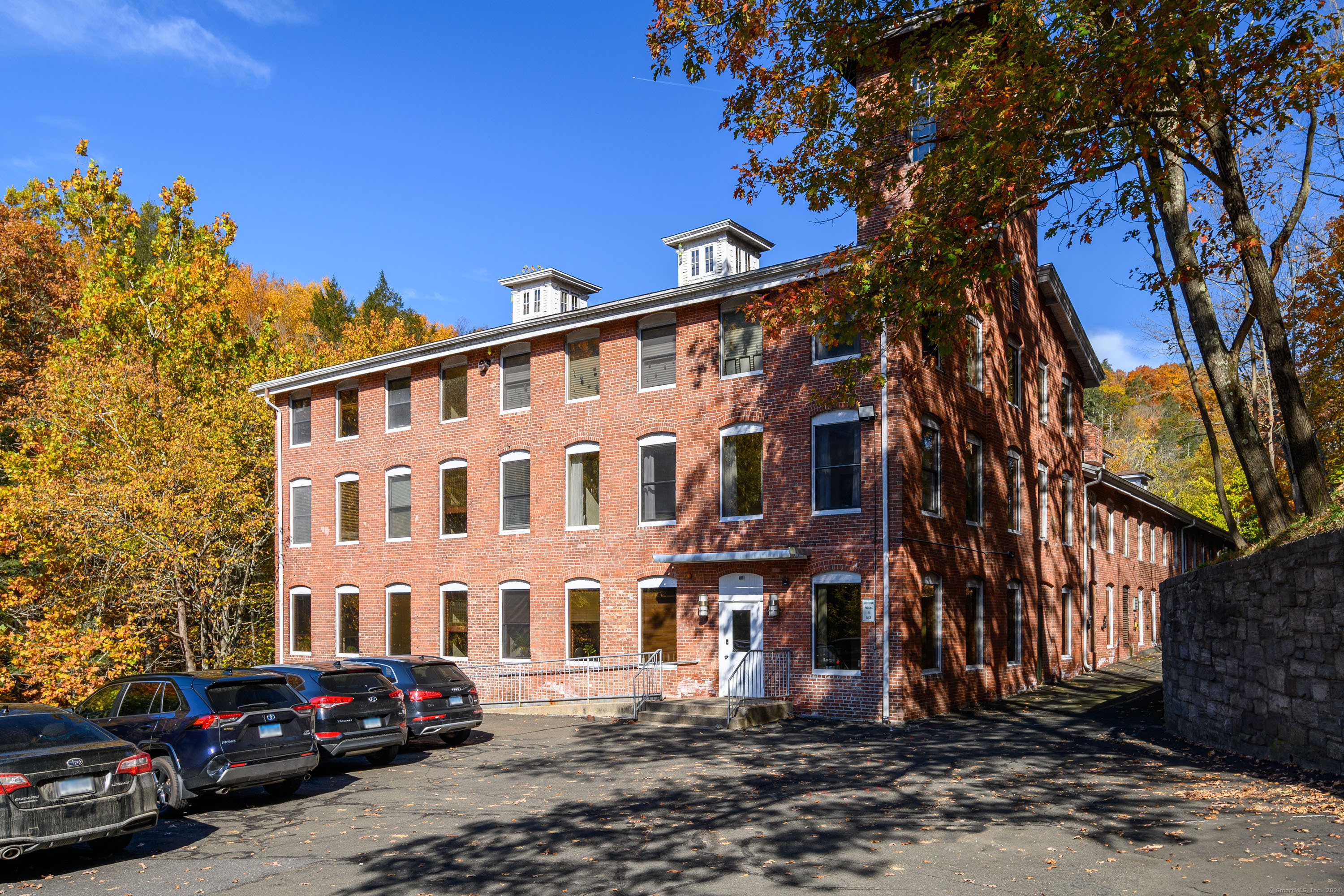 Discover the perfect professional setting on the 4th floor of Rocky Glen Falls, nestled along the picturesque Pootatuck River. This bright and inviting 2 room office showcases breathtaking views, charming exposed brick walls, and a vaulted, beamed ceiling. The suite provides a tranquil environment ideal for focused work, complemented by two other medical-use offices currently in operation. Available for lease is unit 401 and Unit 402, which are connected by a locking pocket door, offering the flexibility to create a larger, cohesive office space or two separate office spaces. Embrace the convenience of a turn-key solution with this fully furnished office, featuring a traditional desk and chair, a treadmill desk for healthy work habits, and ample storage with shelving and cabinets. Additional amenities include a shared waiting room, a common hall kitchen, and public restrooms, ensuring a comfortable and professional atmosphere. Accessibility is seamless, with options to reach the 4th floor via stairs or the building's elevator. While utilities are included, tenants are responsible for setting up their own phone and Wi-Fi services. The location is prime, just a stone's throw from the heart of Sandy Hook Village, where charming shops and delightful restaurants await. Also convenient access to exits 10 and 11 of I-84.