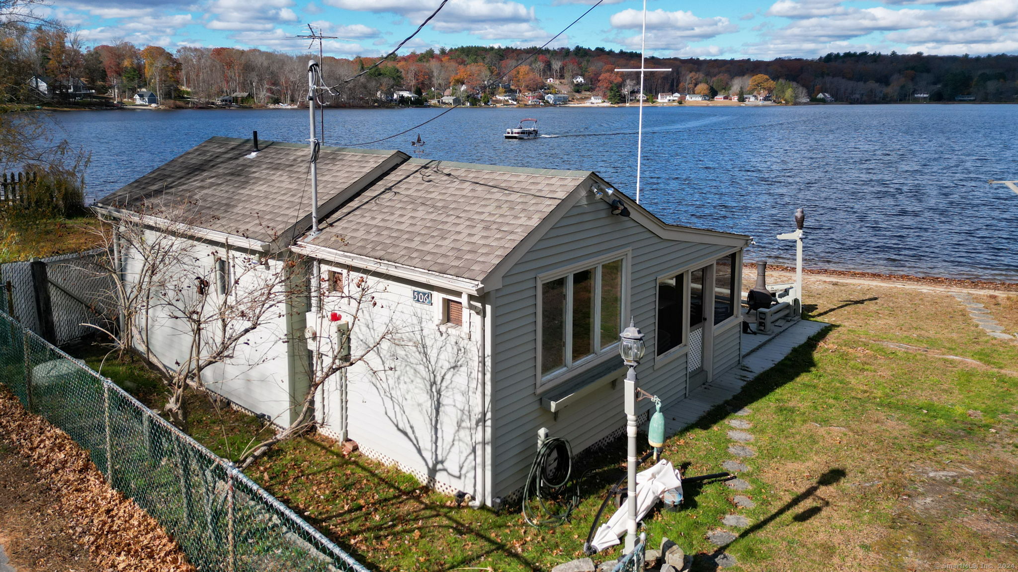 One of the most PICTURESQUE views of Moosup Pond can be yours! This seasonal cottage has city sewer, drilled well and electric heat for those chilly nights! Large front, ground level deck that spreads across the front is only a few feet away from the gentle waves rolling on shore! Inside you have a bird's eye view of the lake lying in bed and a living room with triple windows across the front! A screened in covered porch is perfect spot for the rainy summer day or to enjoy the evening sunset!