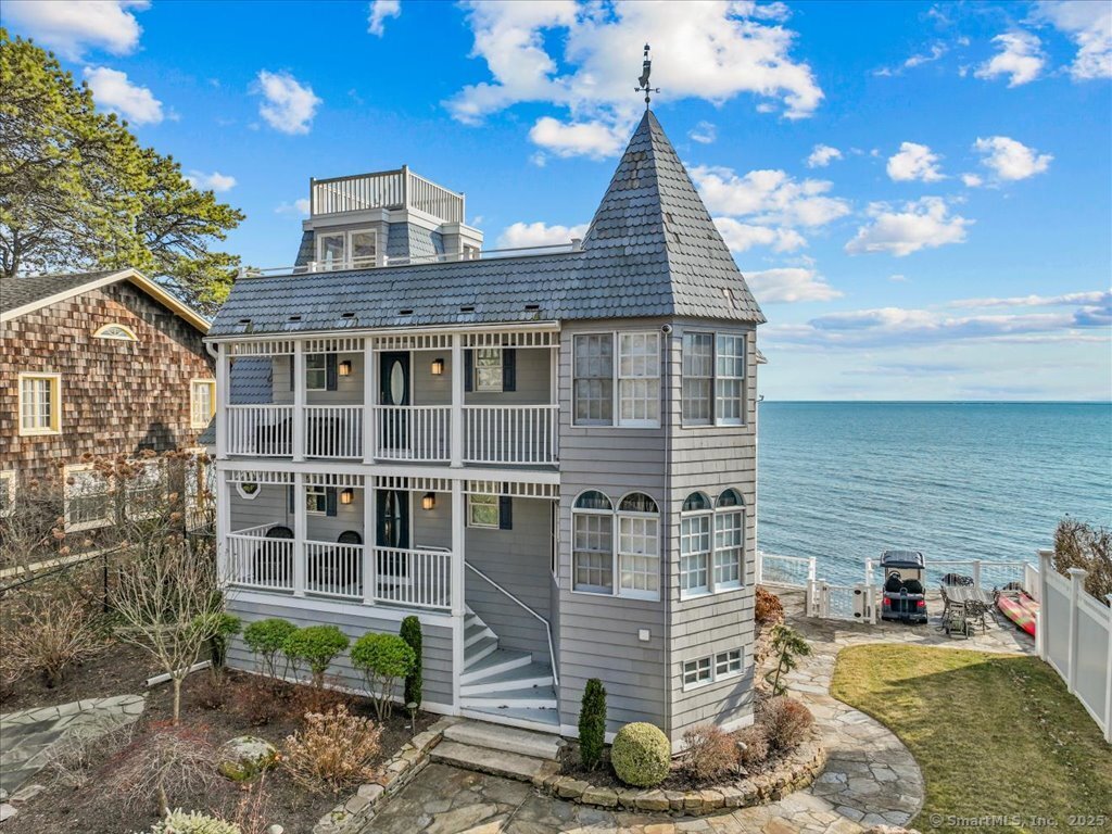 Spectacular waterfront estate offers unparalleled views of Long Island Sound & Duck Island, your own private sandy beach with 72' of frontage + a separate deeded 1.15 acre lot currently paved for additional parking. 61 Grove Way with its stately Victorian exterior aesthetic, is designed to maximize the experience of waterfront living on every level of the home. Spacious open-concept remodeled interior living spaces blend elegance with functionality. A state-of-the-art kitchen w/ heated floors, granite counters, gas range, high-end appliances, large island & sunny turret breakfast nook is a natural gathering place. Open Living/Dining Area w/ hardwood floors, floor-to-ceiling glass walls & large sliding doors allow sunlight to flood every corner while providing uninterrupted vistas of the shimmering water. Expansive covered decks extend from the house creating outdoor living spaces perfect for lounging, entertaining, or simply soaking in the serenity of the setting. Upper level offers 3 bedrooms designed as personal retreats. Master suite w/ glass sliders to water-facing balcony and bathroom w/ heated floor, stall shower & double sinks. Second bedroom also w/ glass sliders to share the covered deck. This level includes a 3rd bedroom, a cozy turret sitting room & front-facing covered deck. Ascend to the 3rd level for exquisite views of Long Island Sound from the rooftop terrace. Lower level is an entertainer's dream w/ Rec/Playroom & Event Kitchen offering storage galore...