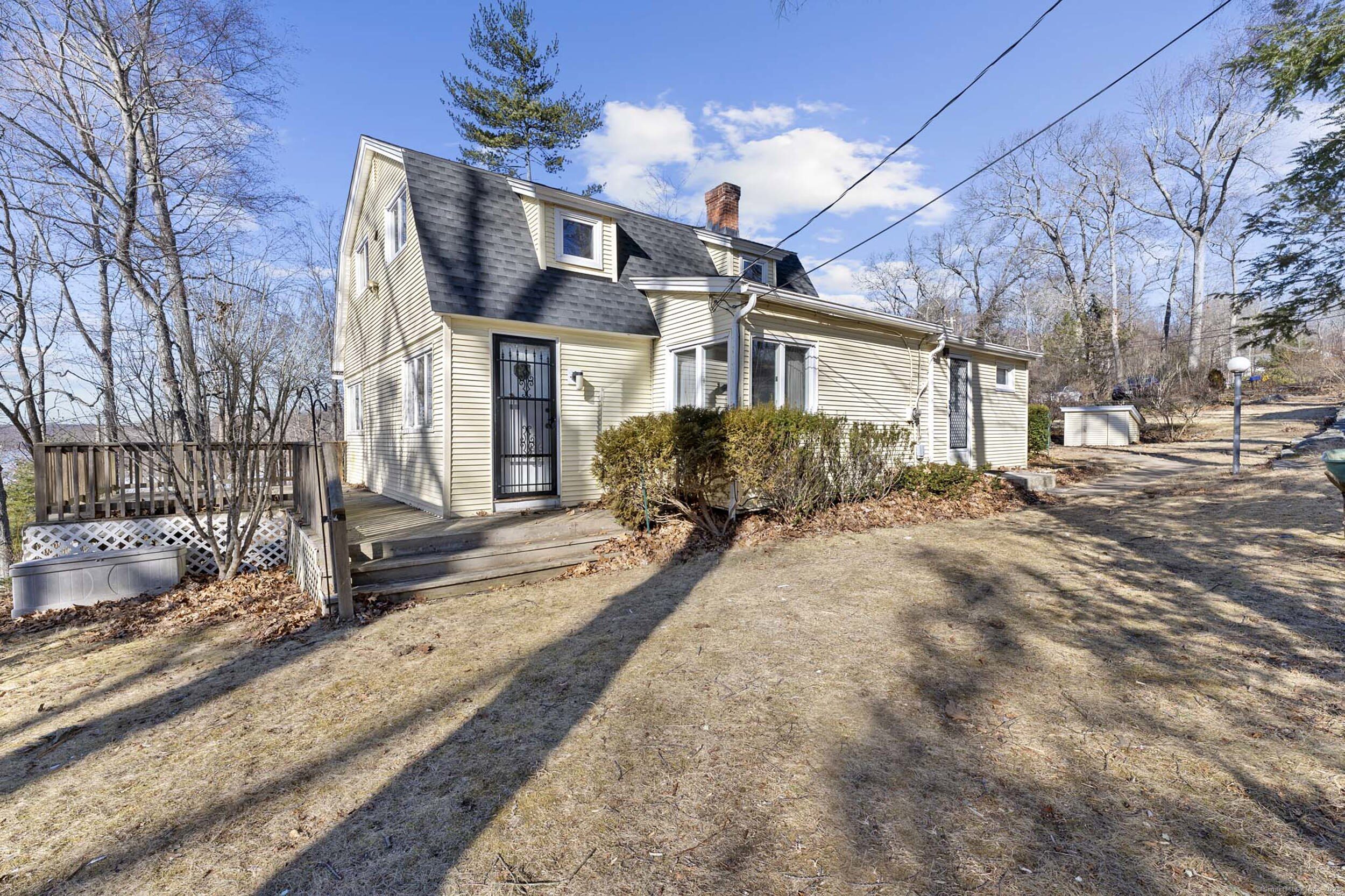 Lakefront Living with Cozy Charm! This 3-bedroom, 1-bathroom Colonial home sits on an elevated lot with panoramic views of Coventry Lake. Inside, the spacious living room features a stunning fieldstone fireplace, creating a warm and inviting atmosphere-perfect for cozying up on cool evenings. Outside, the lake is just a few steps away, offering endless summer fun-fish, swim, paddleboard, kayak, or take your motorboat or jet ski right from your own private dock. When winter arrives, enjoy ice fishing and skating right at your doorstep. Conveniently located halfway between Boston and New York, this property is the best of both worlds-peaceful lakeside living with easy access to city amenities. The home needs some TLC, but it's connected to Town sewer, so no worries about septic system issues. If you've always dreamed of lakefront living, this is the one you've been waiting for!