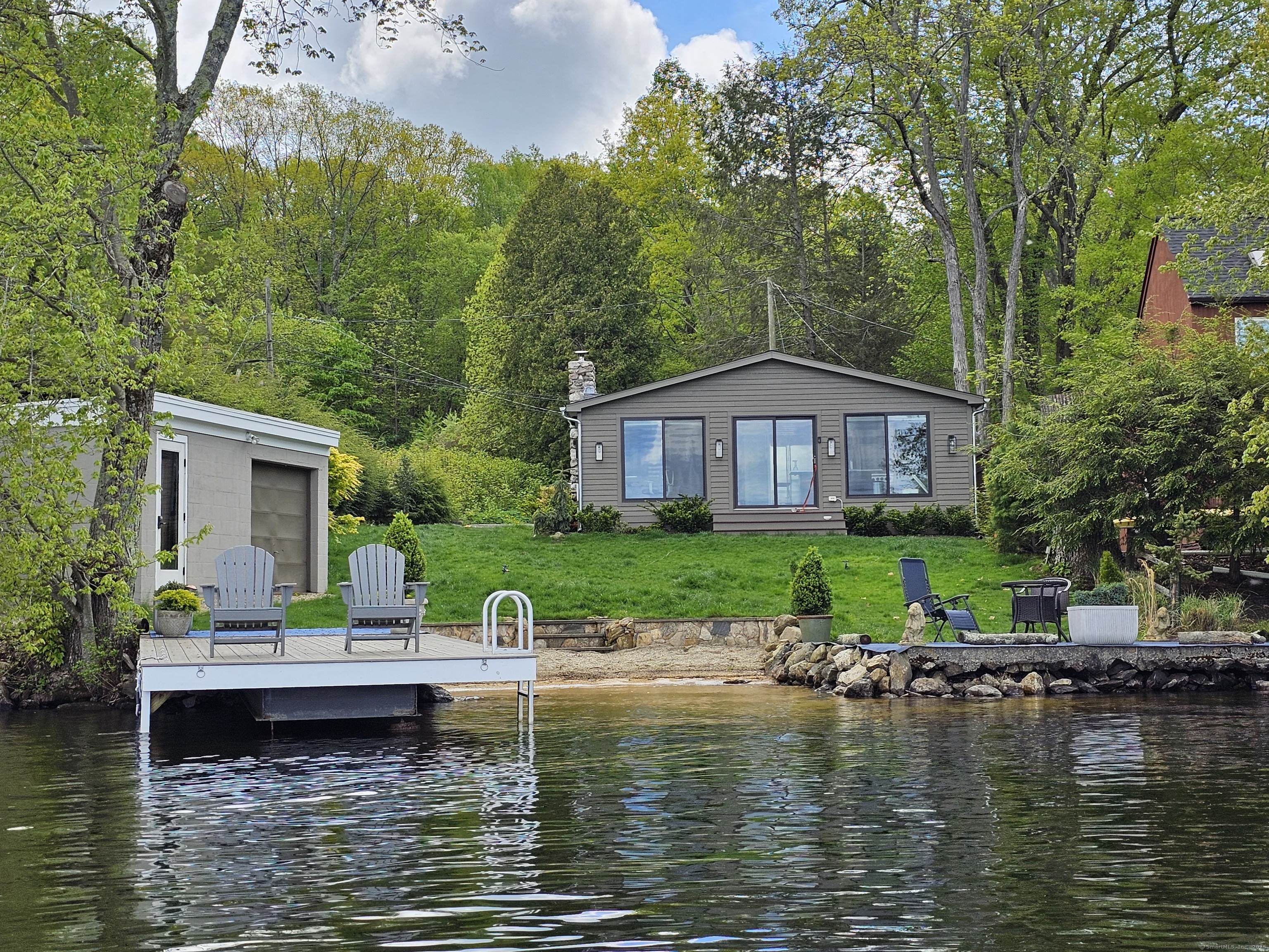 This property is an ideal retreat for nature enthusiasts and outdoor lovers. Located on the West Shore of Lake Quassapaug in Middlebury, CT, it provides a tranquil setting with nesting bald eagles and abundant wildlife. The lake, stocked with bass and trout, offers excellent fishing opportunities directly from the dock. The property is also conveniently close to Flander's nature trails, perfect for scenic hikes. Activities such as canoeing, kayaking, fishing, and swimming are readily available. Additionally, Quassy Amusement Park is nearby, offering fun for all ages including a water park. Visit the new Tranquility Vineyard & Winery located just across the lake. The property is minutes away from excellent restaurants, summer theatres, shopping, coffee shops, and other amenities. New York City is only 90 minutes away. The house was completely renovated in 2020 and includes two bedrooms, two bathrooms, a washer/dryer, a designer kitchen equipped with a commercial Wolf oven and range, a Sub-Zero refrigerator, and a breakfast bar. Newly installed high-speed wired and Wi-Fi internet ensures connectivity. The house also features a 20kw Generac generator and switch for power outages. During the summer months, the lake enforces a speed restriction of 6 mph. The beautiful sunrises and moonlit evenings provide a picturesque environment that will make you reluctant to leave. This is the property for an exceptional summer vacation experience.