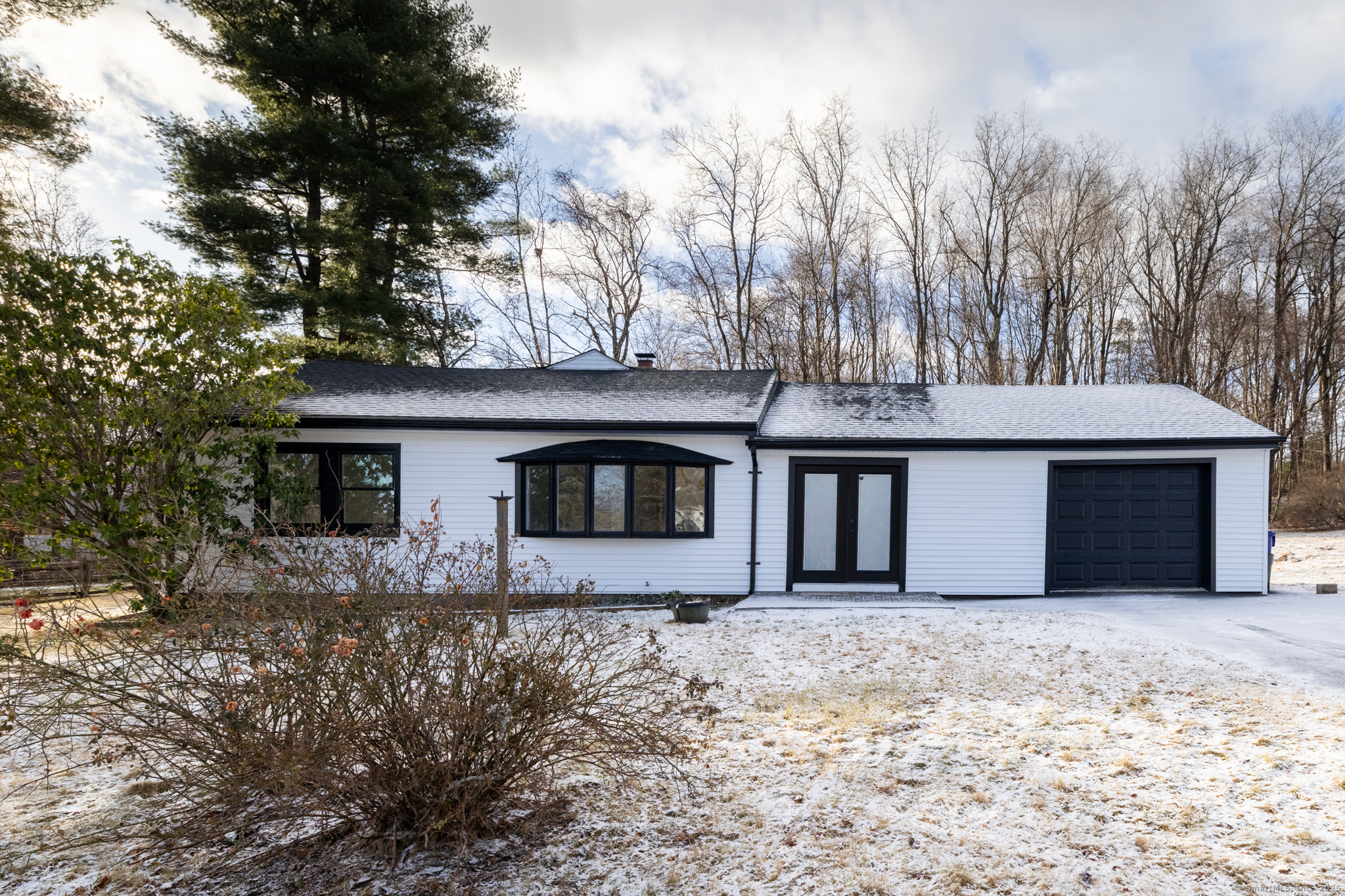 This beautifully remodeled ranch home has a modern open concept. The kitchen features quartz countertops, stylish backsplash, a central island, new cabinetry, and stainless-steel appliances. Recessed lighting throughout the home highlights the upgraded finishes. The large primary suite has exposed beams and shiplap on the ceiling and a very large, fully remodeled bath complete with a walk-in shower and tiled walls. The living room has a vaulted ceiling and exposed beam, creating a bright and airy atmosphere with French doors going out to the new patio. A huge dining room provides ample space for family gatherings. The other two bathrooms are generously sized, offering convenience and comfort. The large, finished basement adds approximately 550 square feet of additional living space, perfect for a home office, media room, or recreational area. It also includes a private laundry area. The home features an attached one-car garage and a large detached two-bay garage, ideal for a workshop or an enthusiast's auto collection. The home has a new central air system, a flat backyard with a patio for outdoor enjoyment, and new siding with black farmhouse windows, this home combines style, functionality, and comfort.