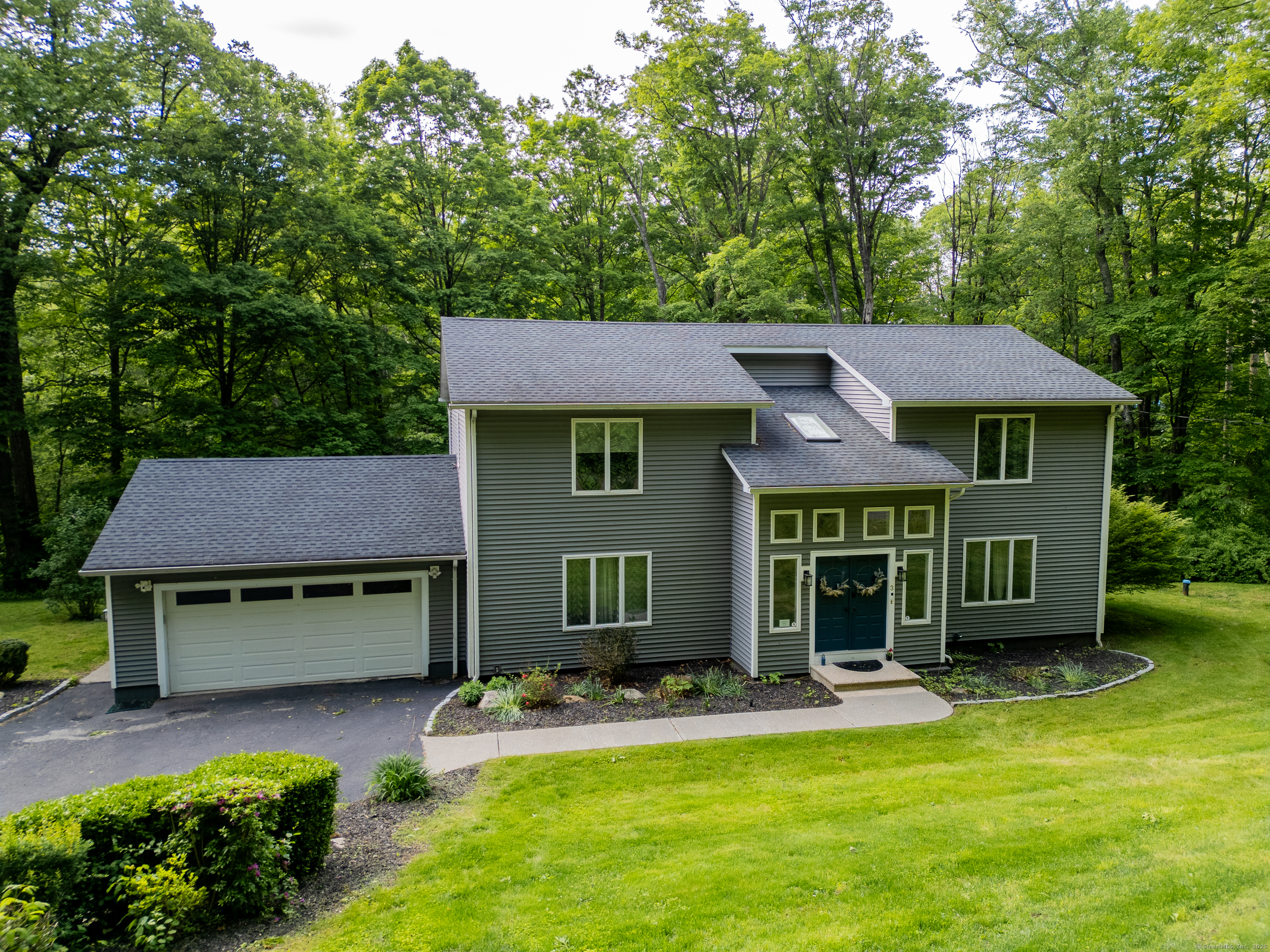 A gently running brook winds through the backyard of 3 Morrissey Lane, setting the tone for this nature-filled retreat in the scenic Gaylordsville section of New Milford. The peaceful sound of flowing water creates a serene backdrop for everyday living in this 3/5 bedroom, 3.5-bath home offering over 2,500 sq. ft. of above-ground living space. Step into a light-filled foyer and enjoy an open, airy layout perfect for both relaxed living and entertaining. The main living area flows seamlessly to a spacious deck-ideal for outdoor dining and taking in the natural surroundings. The oversized primary suite offers a luxurious escape with its spa-like en-suite bath, while an oversized bonus room on the main level provides flexible space for a den, office, or playroom. The finished lower level presents even more versatility, including the option for an in-law setup. Additional features include a 2-car garage, central air, high-efficiency propane on-demand hot water, a generator hookup, and a cozy outdoor firepit-all tucked away on a quiet street in one of New Milford's most charming neighborhoods.