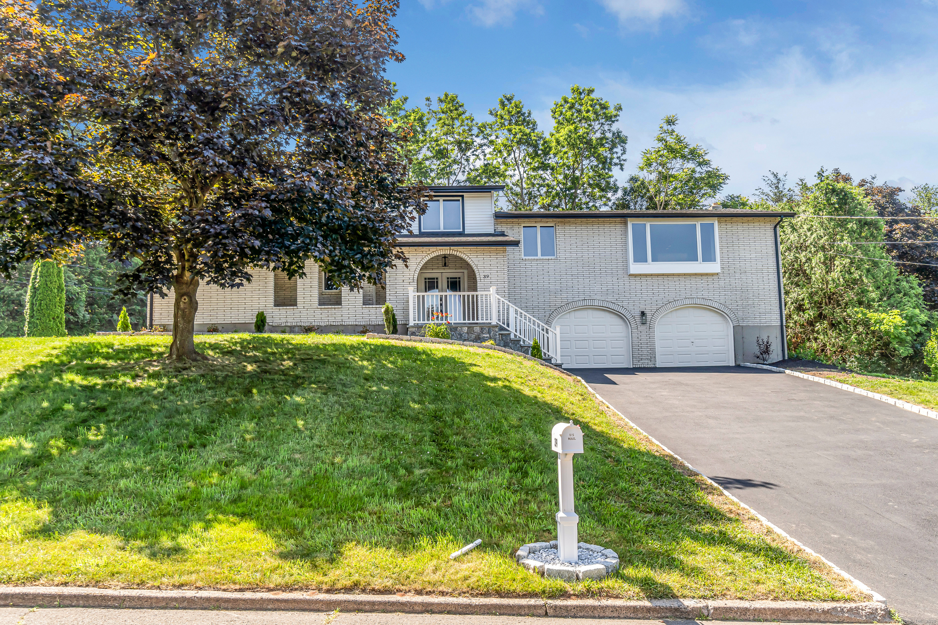 Step into this beautifully renovated mid-century modern home, upgraded top to bottom by a quality builder with attention to every detail. Featuring an open floor plan with plenty of room for the whole family. A brand-new modern kitchen with sleek finishes, large waterfall quartz island, and high-end appliances makes this home perfect for today's lifestyle. The spacious primary suite boasts a large walk-in closet and a luxurious en-suite bath with a double vanity and oversized shower. Generously sized bedrooms offer plenty of space for family or guests. The fully finished, above-grade walk- out lower level includes another oversized family room with stylish grey brick fireplace, another bedroom, full bath, and bonus room-ideal for a home office, gym, or playroom. Perfect as an in-law set up or extra living space for the family. Nothing left untouched including new trim and doors, new hardware, and LED lighting throughout. Enjoy year-round comfort with a new furnace, central air system, and Navien on-demand hot water heater. Outside, the private level yard boasts tons of outdoor living perfect for entertaining with a large new Azek deck and a new oversized patio. Add a brand-new driveway for convenience and new bluestone covered porch entrance and walkway. Don't miss this turn-key gem that combines modern design with quality craftsmanship. Literally nothing to do but move in.