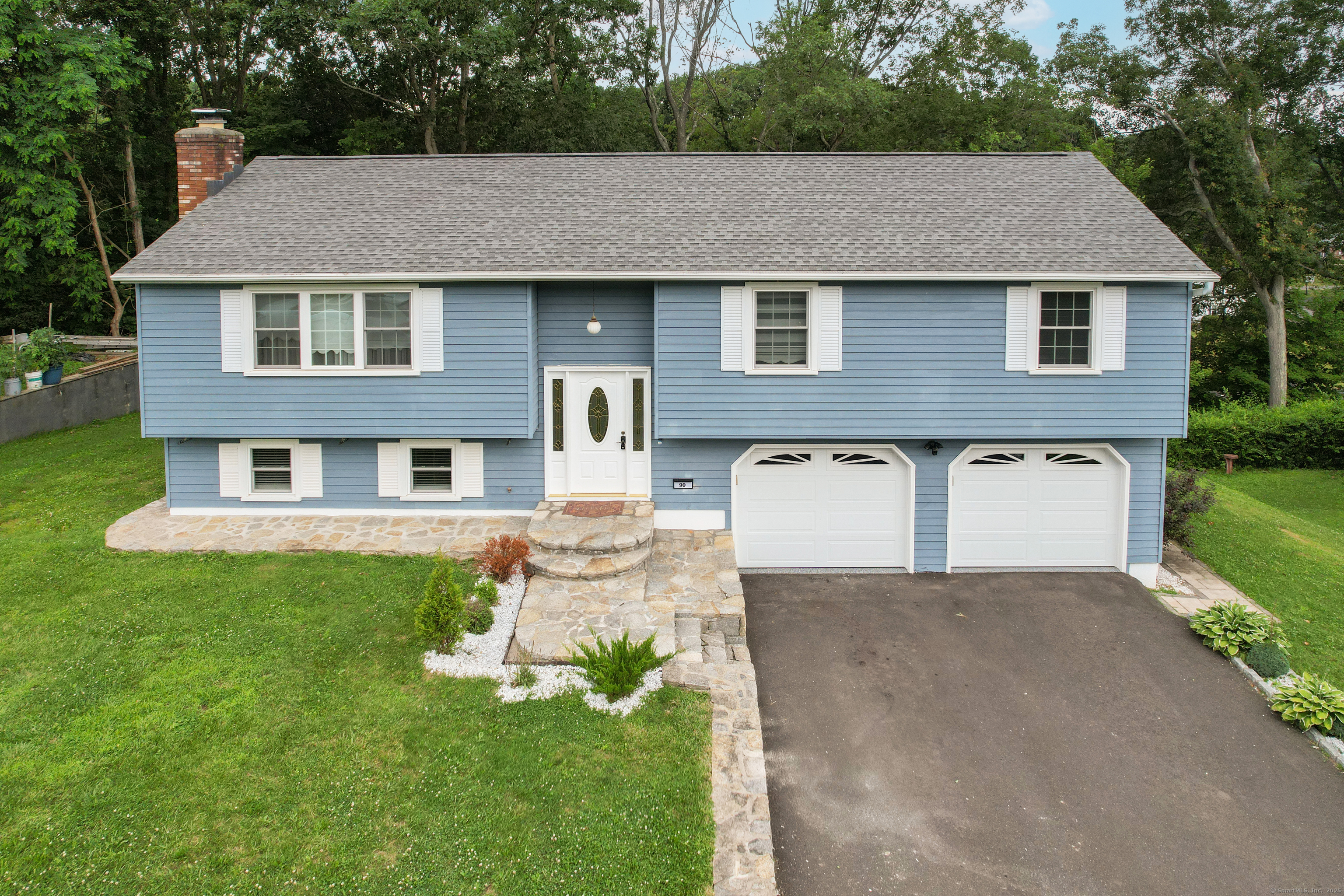 Completely remodeled and thoughtfully upgraded, this stunning raised ranch in Waterbury's sought-after Bunker Hill neighborhood offers style, space, and versatility! Featuring 3 bedrooms and 2.5 baths, this home also offers a beautifully finished in-law/studio apartment in the lower level with its own entrance, natural gas fireplace insert, full kitchen, bath, and sliders leading to a private patio. Upstairs, enjoy an open and airy layout with gleaming hardwood floors throughout and a gourmet kitchen designed for both function and flair. Custom-tiled bathrooms add a touch of luxury; including a full ensuite bath in the primary bedroom. Sliders off the main living area lead to a composite deck-perfect for outdoor dining or relaxation. Additional highlights include a 2-car garage with epoxy flooring, central air, and thoughtfully designed stone and woodwork trim and details that elevate every space. Whether you're hosting guests, accommodating extended family, or simply enjoying everyday comfort, this home checks all the boxes.