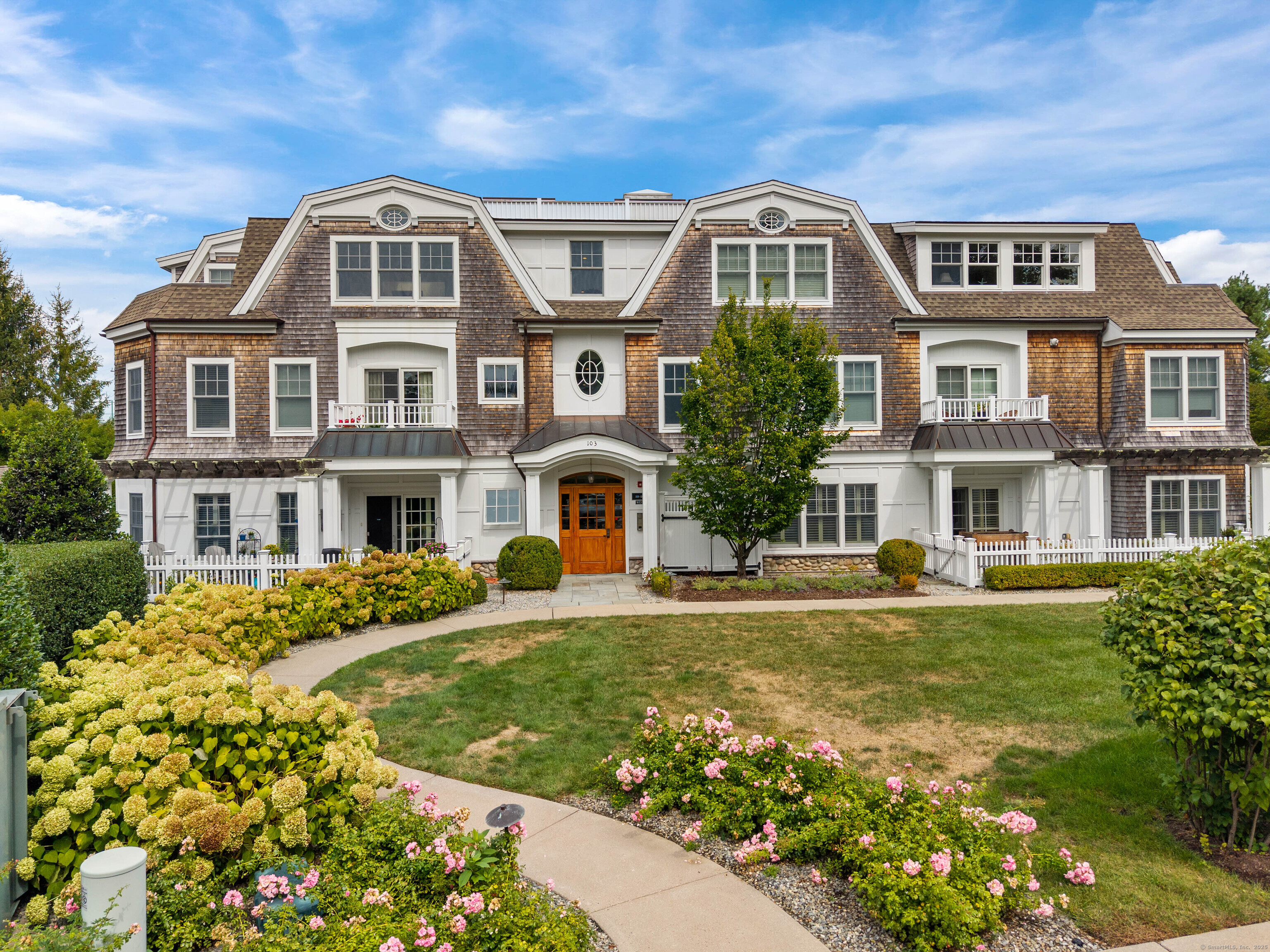 Stonington Borough Living at Its Finest! Welcome to a rare coastal treasure in the heart of Stonington Borough. Experience the epitome of coastal elegance with this beautiful first floor end unit condominium featuring 2 bedrooms and 2 full baths. The interior layout emphasizes an open, bright living experience, integrating the kitchen, dining area, and living room to create a spacious environment. The kitchen features stainless steel appliances, generous counter space, and ample cabinetry, while the spacious living room features a traditional-style fireplace. The office, which may also serve as a den, could possibly be converted into a third bedroom, opens to a private patio with a wooden pergola and white picket fencing offering a peaceful space to enjoy fresh coastal air. The primary suite showcases an ensuite bath and spacious walk-in closet. Tray ceilings accent the office and primary bedroom, while hardwood floors flow throughout the condo. An assigned carport ensures convenience while manicured grounds and scenic walkways complete the picturesque setting of this grand, multi-story condominium complex, offering a graceful complement to its historic surroundings. Enjoy worry-free ownership as part of a well-managed homeowners association, with the master flood insurance policy paid for by the Association.