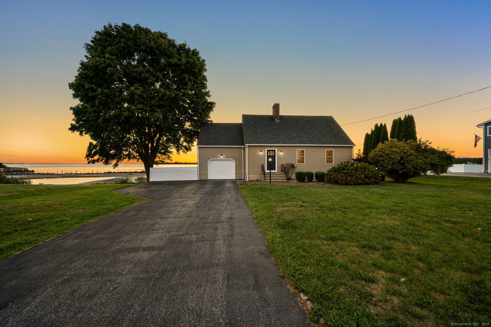 Picture this: you wake and step onto the beach for a morning of swimming, fishing, and sunbathing. You walk down the street for a mid-day grinder before an afternoon of golf around the corner, a quick drive to Niantic village for dinner, and back home for an evening drink on the back deck while enjoying panoramic sunset views. This can be your new lifestyle at 25 Division St, a beautifully remodeled 3/4 bedroom Cape offering a year-round waterfront vista & DIRECT ACCESS to Jordan Cove & the LI Sound. Inside, the herringbone tiled foyer opens to the family room with a fireplace for colder nights, & a slider leading onto the custom multi-level Mahogany deck overlooking the Sound. The open concept gourmet kitchen features soft-close cabinetry, marble counters & backsplash, stainless steel appliances, & large pantry for added storage. Refinished gleaming hardwoods flow through the main level, which is finished with a full bath including a stand-up tiled shower for washing off the sand, & a one-car garage. Upstairs are 2 well-appointed bedrooms and another full bath featuring a shower/tub combo with custom ocean-blue tile surround. The primary bedroom also leads to a large dormered 21'x16' unfinished space which could eventually complete your primary en-suite with a full bath & walk-in closet (among other options). To top it off, the full basement is partially finished with laundry area, 2 large finished/heated rooms for a rec room, office space, or bedroom, & a workshop area.