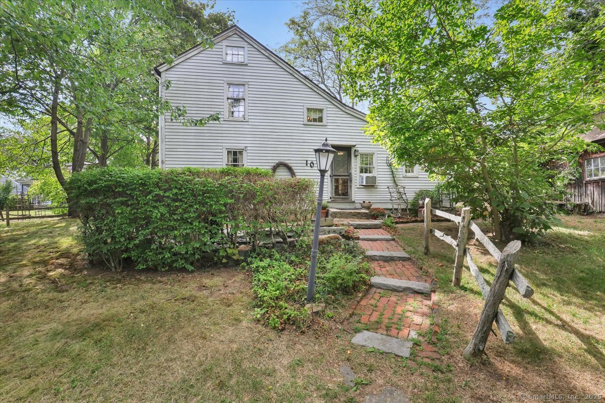 Step back in time with this one-of-a-kind 1672 Colonial Saltbox, a true treasure in the heart of Niantic. Offering 1,719 sq. ft. of living space, 3 bedrooms, and 2 baths, this home provides a rare opportunity to own a piece of CT's early history while enjoying modern functionality. The home's classic saltbox design- catslide roof, exposed beams, and central chimney-beautifully reflects its colonial heritage. Step inside the entry hall, which offers abundant built-in storage and flows seamlessly into the three main rooms that circle the central chimney, each with its own fireplace. To either side of the entry hall are a cozy living room and formal dining room, both connecting to the gathering room, whose fireplace includes a spectacular beehive oven! The kitchen, located off the gathering room on the lean-to side of the home, features breakfast bar seating, creating a warm, social atmosphere. The first floor also offers a snug bedroom and full bath with shower stall. Upstairs, the second floor offers a large bedroom, the primary bedroom with walk in closet, a versatile corridor that could be an office, a galley-style full bath thoughtfully repurposed from the original garret. Original beams and wide-plank floorboards remain beautifully intact, complemented by an attached root cellar and unfinished walk-out basement. Tucked away on a .44 acre lot with rustic landscaping and mature foliage a serene colonial retreat while just two blocks from downtown Niantic. Subject to Probate