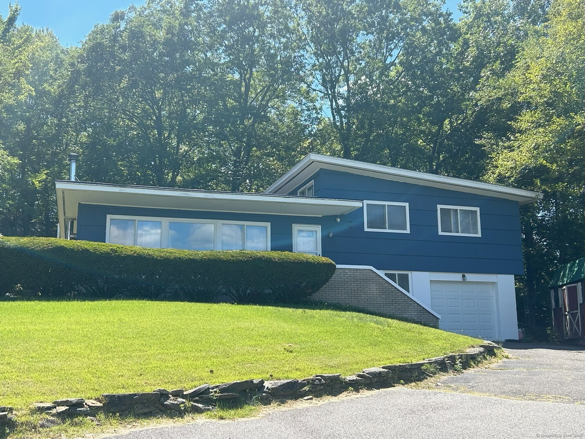 Set on a private corner lot with classic stone walls, this unique split-level home offers both comfort and potential. Freshly painted throughout with brand-new vinyl flooring. Move in ready!! Cozy up by the woodstove in the main living area. Enjoy 3 spacious bedrooms, plus a versatile extra room that can serve as a 4th bedroom, office, or den. Ample storage and an unfinished family room provide endless possibilities to make this home your own. Perfectly situated in a sought-after neighborhood near the Torrington/ Litchfield line. This distinctive home combines style, privacy, and timely appeal.