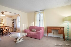 Spacious living room with hardwood floors under carpeting