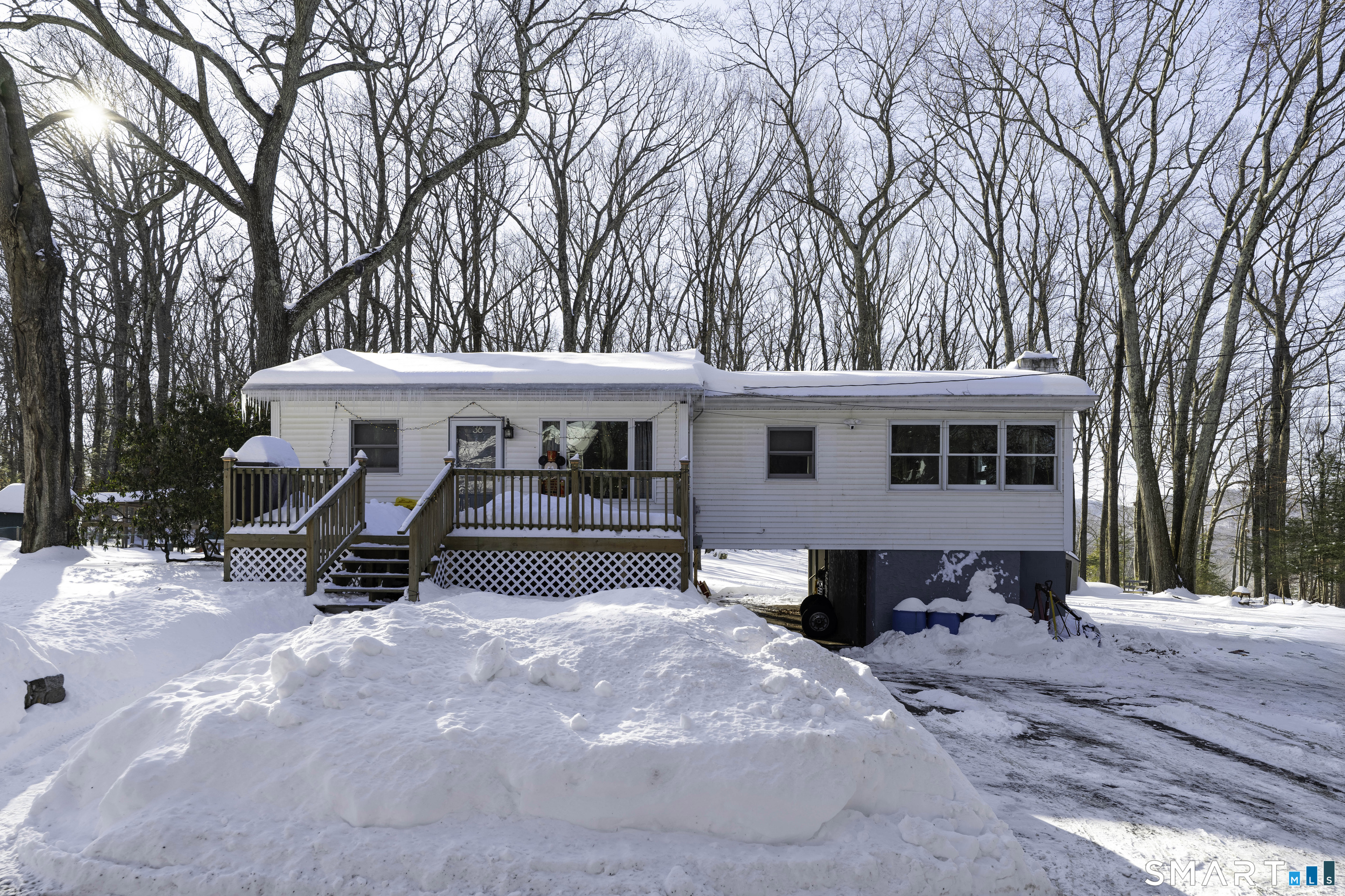 Welcome to this inviting 3 bedroom, 1 bath home located in the Millstone Ridge community, offering year round lake and beach access to Candlewood Lake, including access to the largest beach on the lake. This property offers a wonderful opportunity to enjoy lake living while still providing the comfort and privacy of a single family home, along with great potential as a rental or Airbnb investment.  Inside, you'll find an updated kitchen with quartz countertops, hardwood floors throughout, and a charming stone fireplace anchoring the living room. Abundant natural light creates a warm, welcoming feel across the home. Outside, enjoy a backyard patio perfect for relaxing or entertaining, plenty of parking in the driveway, and relatively newer rock walls in front that add great curb appeal. Whether you're searching for a full time residence, weekend retreat, or income producing property, this home offers a wonderful blend of modern updates, outdoor space, and the rare benefit of year round lake access.