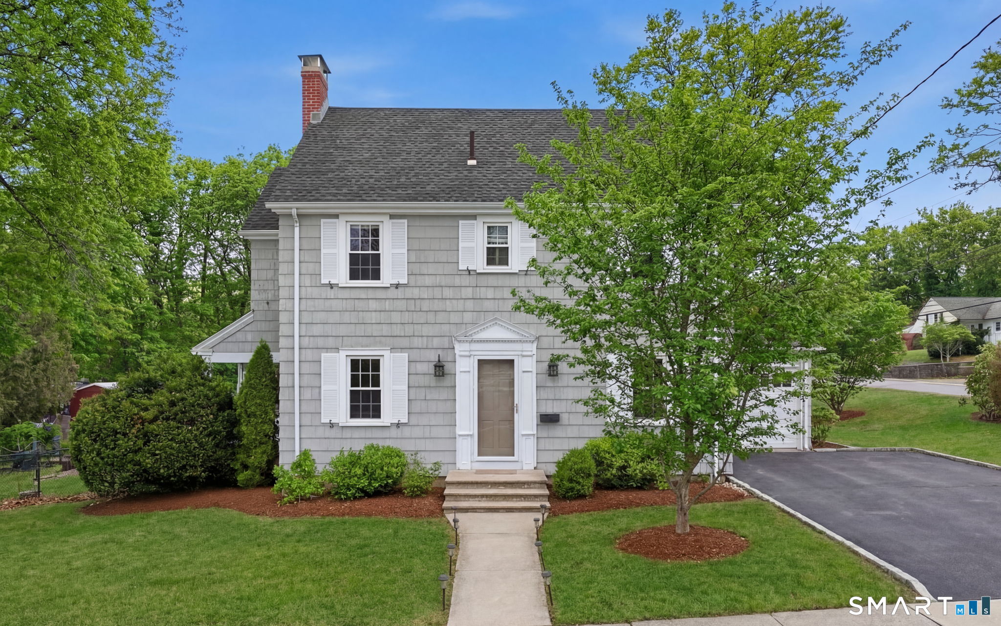 Absolutely won't last long! This beautifully updated Colonial blends classic charm with generous living space and thoughtful upgrades throughout. The spacious living room features a wood-burning fireplace, creating a warm and inviting atmosphere, while the recently updated kitchen offers stainless steel appliances, granite countertops, and soft-close cabinetry. A formal dining room with a built-in corner hutch adds timeless character, perfect for hosting. Upstairs, you'll find large bedrooms with ample closet space, including double closets in the primary bedroom, and one and a half baths conveniently located on each level. Hardwood floors throughout enhance the home's elegance. Additional highlights include an attached garage with mudroom, a shed for extra storage, and newer windows and mechanicals for peace of mind. Mini-split heat and A/C provide efficient comfort across the entire first floor. Designed for outdoor living, the property boasts a private, fenced-in backyard with meticulous landscaping, a fire pit, and a spacious covered deck ideal for entertaining or relaxing. The clean, dry basement includes one finished room, and a huge walk-up attic offers excellent potential to add an office, playroom, or additional bedrooms. Truly homey, inviting, and move-in ready inside and out.