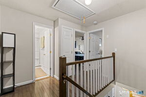 The upper-level landing offers hardwood flooring and easy flow to both bedrooms and the beautifully updated bath.