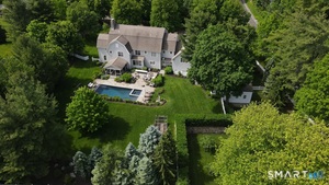 The rear of the home is an expansive, meticulously landscaped oasis with masonry and lush perennial borders that offer year-round privacy and beauty.