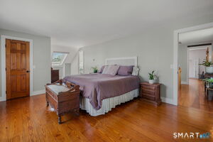 Primary bedroom suite features skylight and wood floors