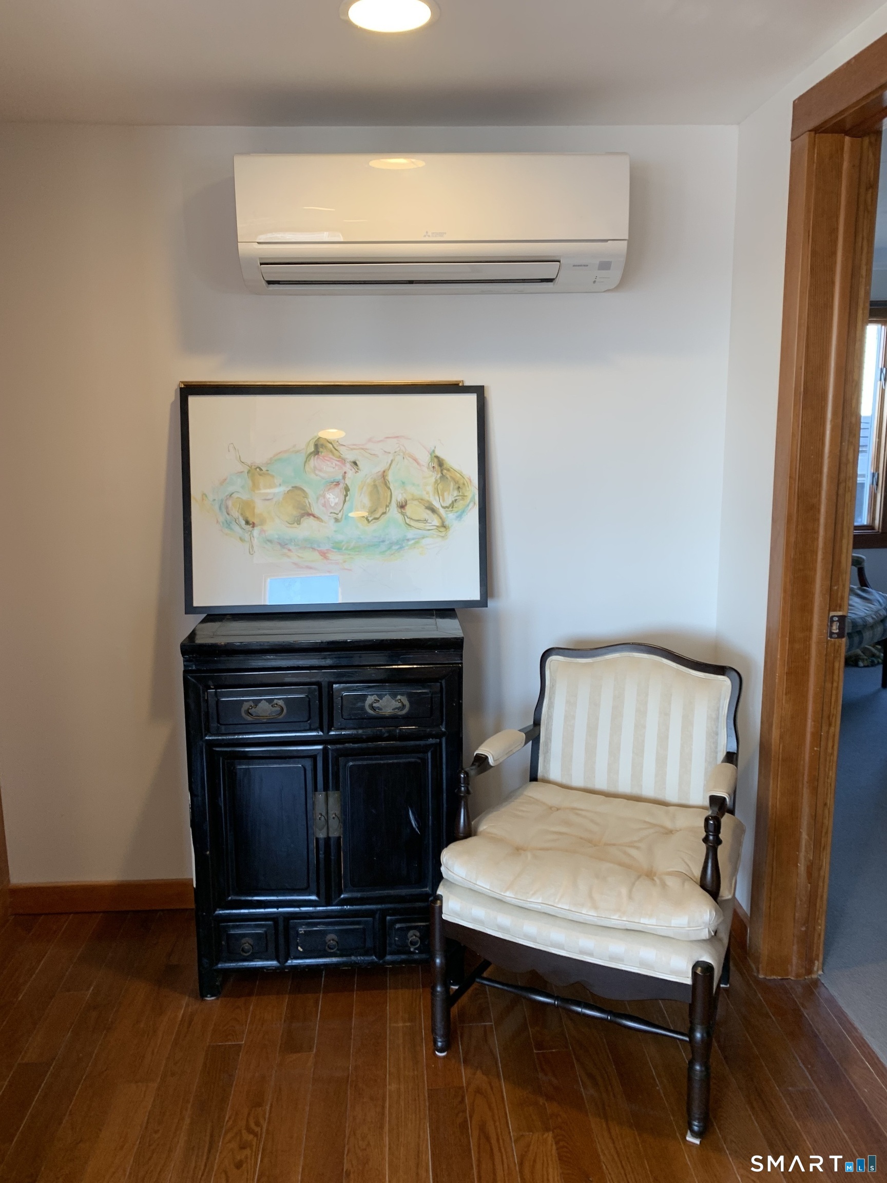 Mini split serves as heat and air conditioning. The apartment has oil heat too. Next the mini split is book shelves, from floor to ceiling.