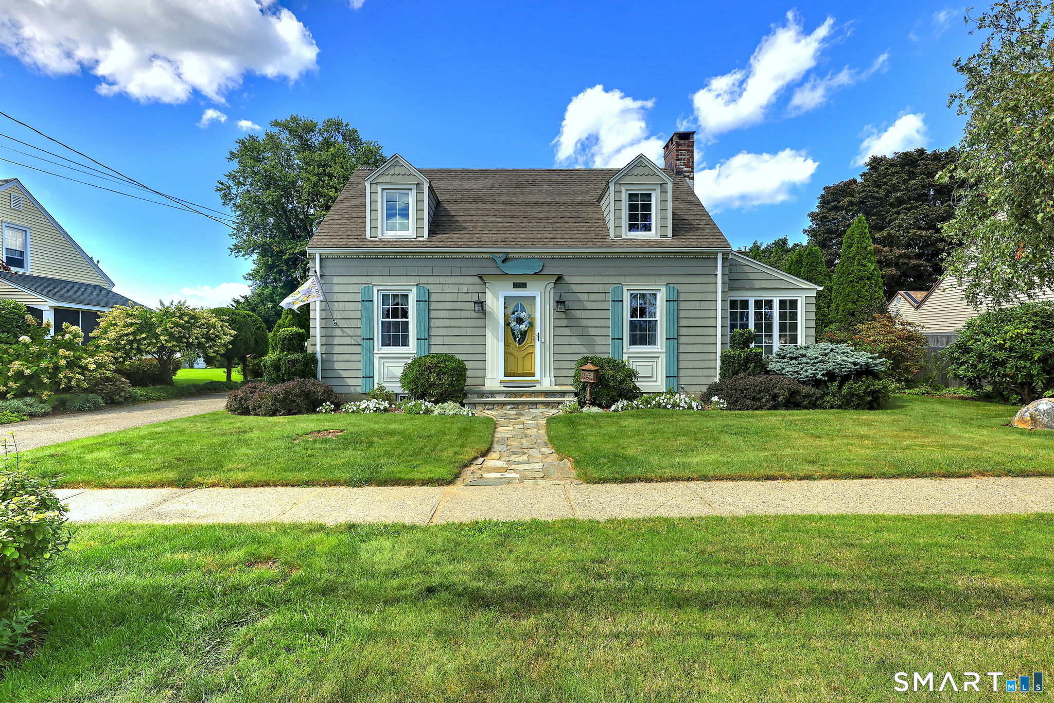 Charm, character, and a coastal setting come together beautifully in this meticulously maintained Cape Cod home in the heart of Lordship, just a short stroll from the water. From the moment you arrive, you know this place is special. Perennial gardens and mature plantings surround the property, creating a colorful setting with something lovely around every corner. Step inside and the feeling continues. This inviting 3-bedroom, 1.5-bath home is filled with warmth and thoughtful details. Hardwood floors, decorative millwork, crown molding, and wainscoting add character throughout. The beautifully remodeled kitchen features stainless steel appliances, distinctive cabinetry, an island with seating, and a bay window welcoming in natural light. Surrounded by large windows, the wonderful sunroom is a bright, inviting place to enjoy your morning coffee and the changing seasons. The living room fireplace, with its beautifully detailed mantel and surround, creates an inviting focal point. The lower level offers flexible space with finished walls and floors. Outside, discover garden pathways and a spacious patio perfect for relaxing or entertaining. Even the detached garage offers something unexpected, with charming double doors opening to a dedicated potting space. With the water just moments away, this coastal jewel is best appreciated in person. Come home to a place that's easy to fall in love with.